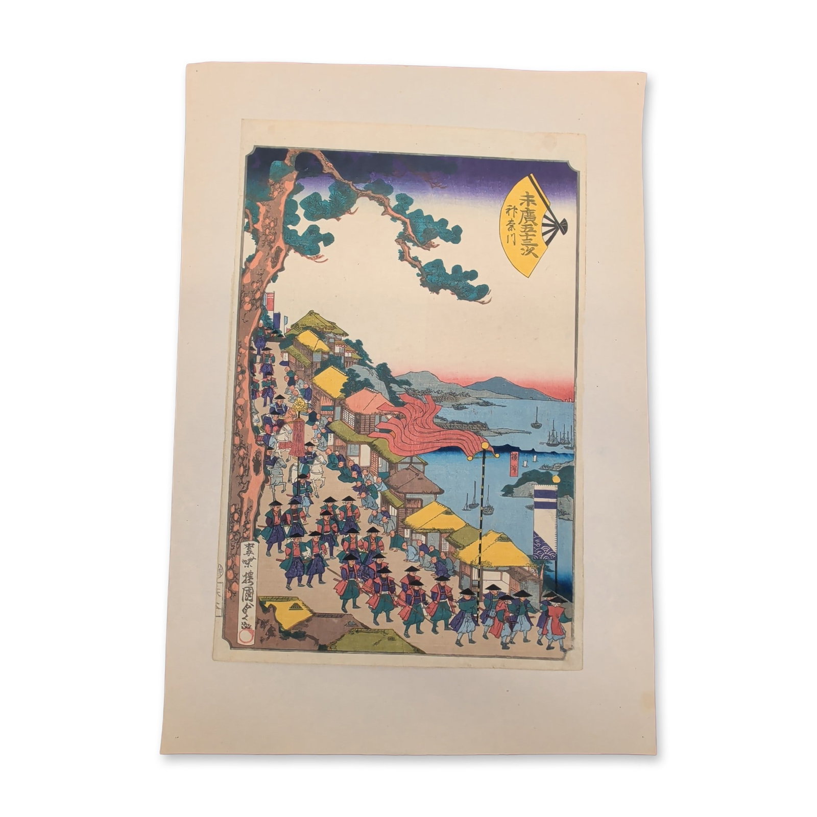 Utagawa Kunisada II (Japanese 1823-1880) Procession Scene along a Coastal Road Woodblock Print: This 19th-century Japanese woodblock print features a vertical format landscape composition depicting a traditional feudal lord's procession traveling along a sloped coastal roadway. A dense