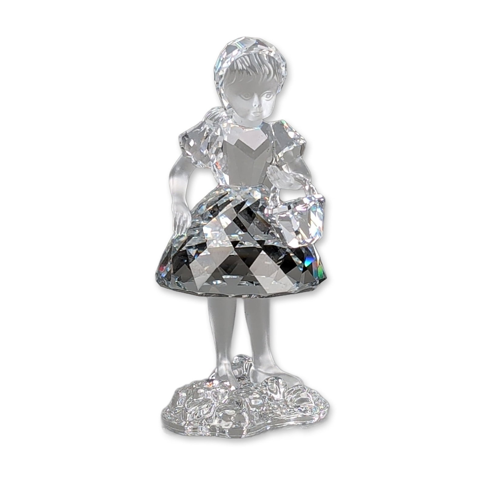 Swarovski Silver Crystal Figurine, Red Riding Hood with Basket: Swarovski figurine part of the Fairy Tales series, featuring a frosted head and limbs, a faceted bodice, and a large flared faceted skirt. The figure is mounted on a textured clear crystal base. The f