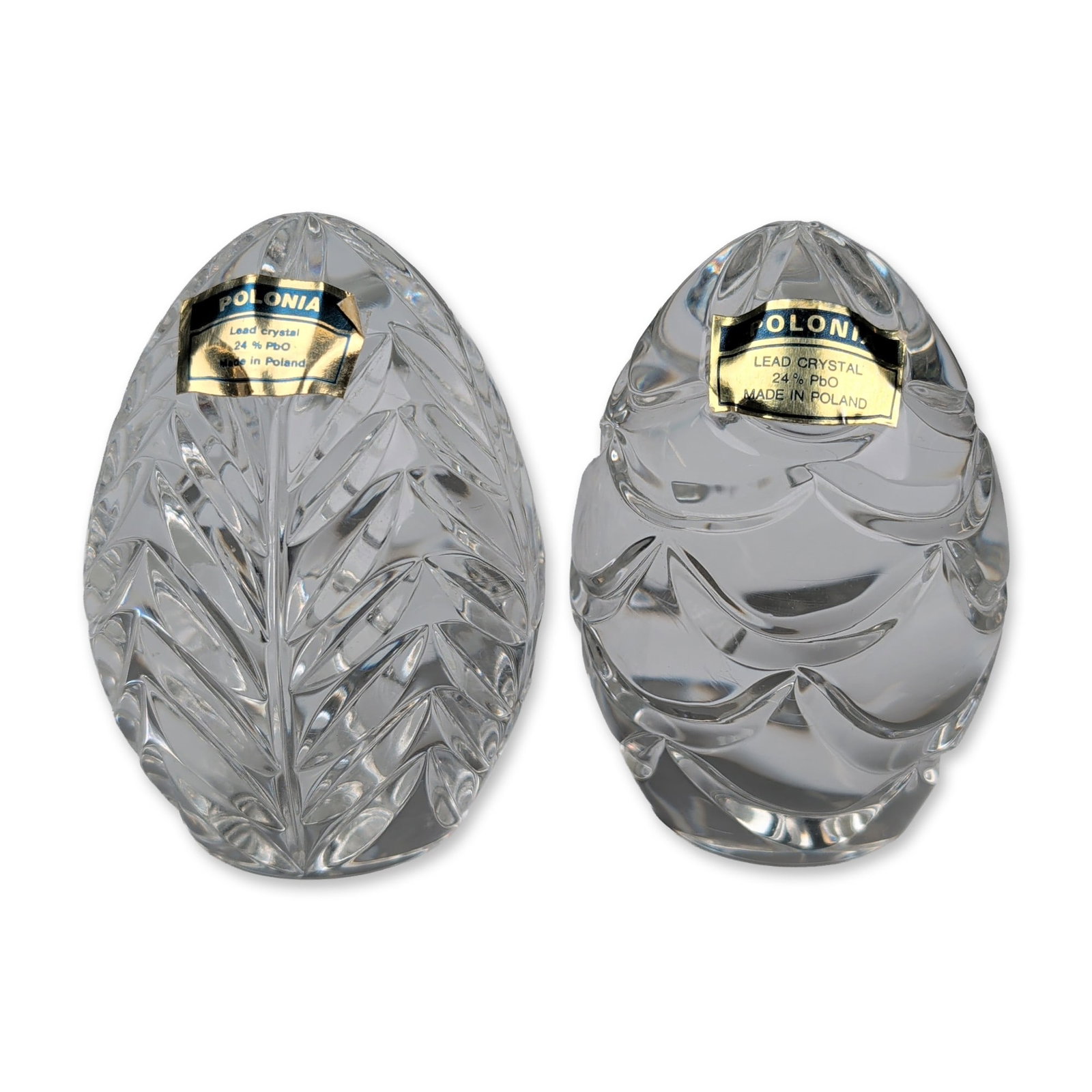 2pc Polonia Polish Lead Crystal Egg Paperweights: Each piece features hand-cut patterns in 24% lead crystal, with one displaying a stylized vertical leaf or wheat sheaf motif and the other a horizontal scalloped wave design. Both eggs are finished wi