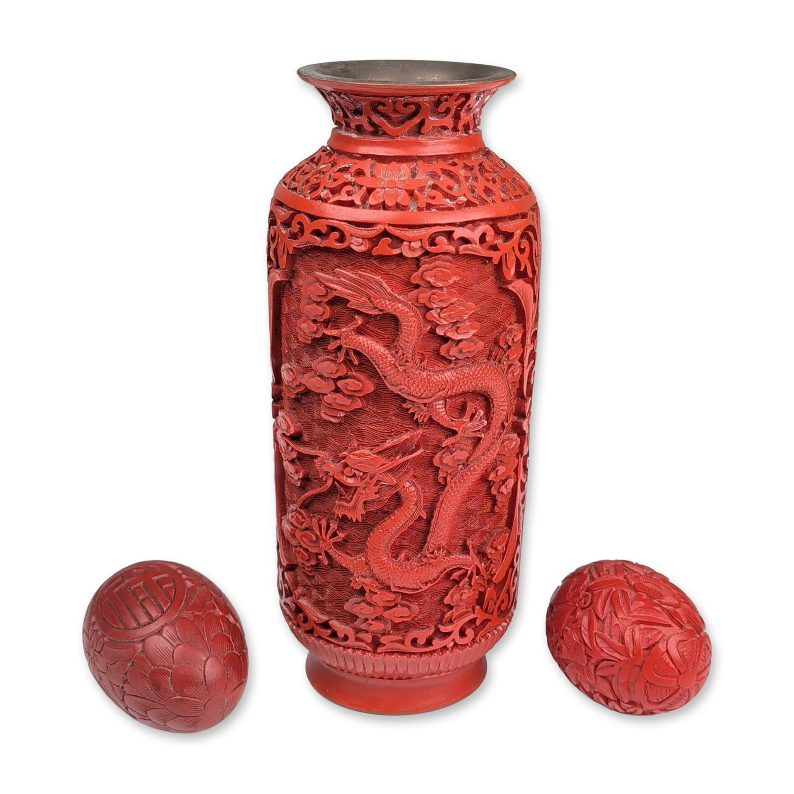 3pc Chinese Carved Cinnabar Lacquer Vase and Eggs: Chinese carved cinnabar lacquer trio consisting of one cylindrical vase and two ovoid eggs. The vase features a metal core with a deep red lacquer surface, decorated with a continuous scene of two fiv