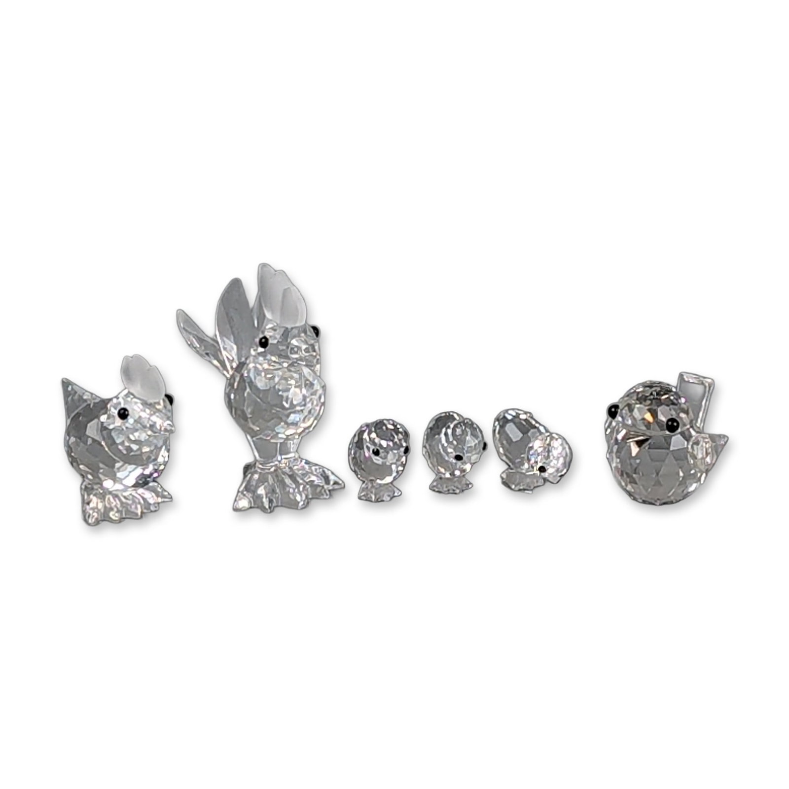 Group of 4 Boxed Swarovski Silver Crystal Figurines- Rooster, Hens, and Chicks: Collection of seven figurines depicting a rooster, a hen, three chicks, and an a baby chick figurine. Each piece is crafted from faceted lead crystal and features small black bead eyes. The rooster an
