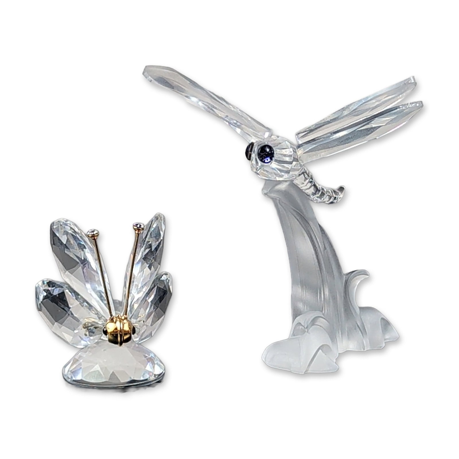 2pc Swarovski Silver Crystal Pollinator Figurine Set: This crystal pair features two-winged specimens from the Swarovski Silver Crystal line, consisting of a dragonfly on a leaf and a butterfly. The dragonfly figurine features transparent faceted wings a