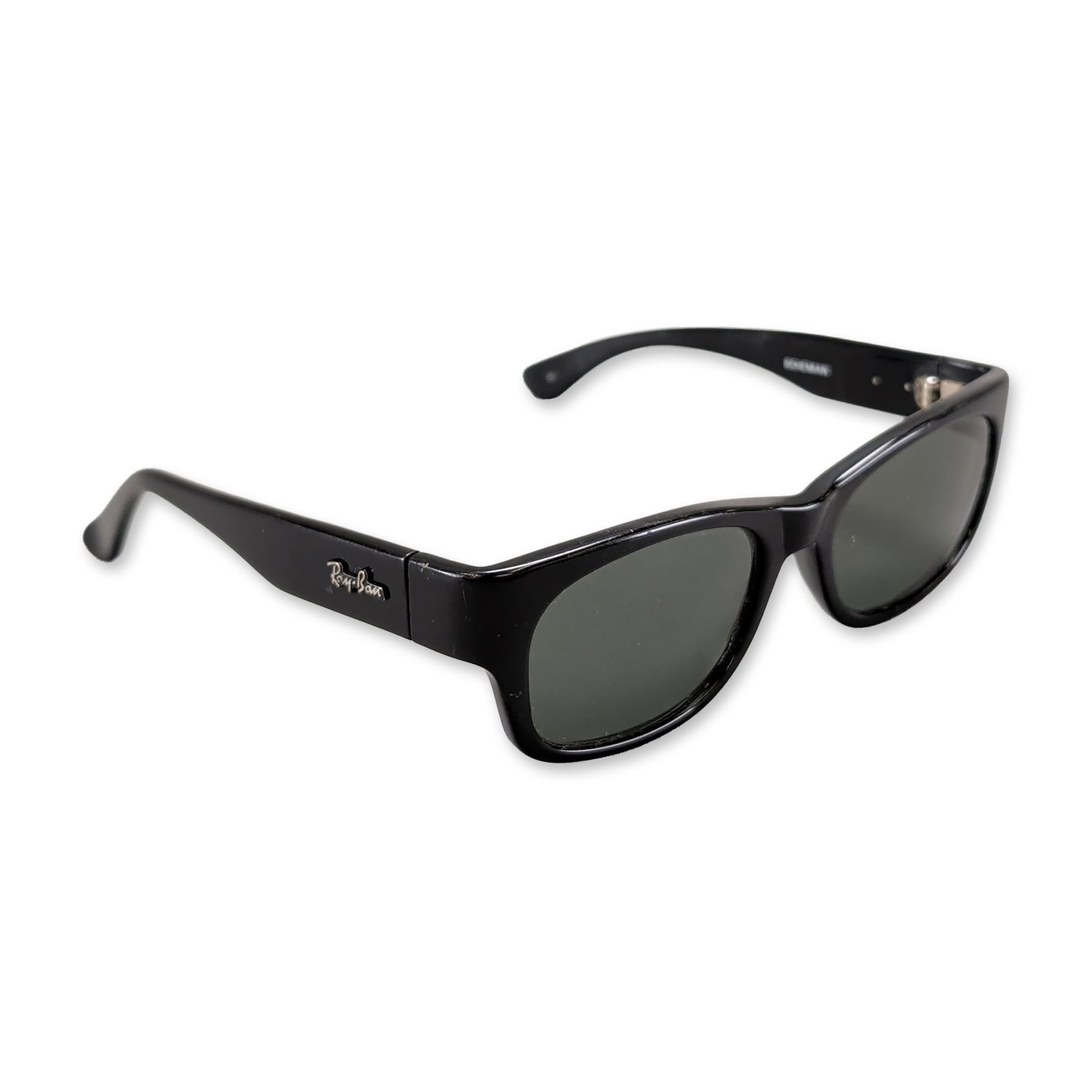Ray-Ban Bohemian Black Acetate Sunglasses: Ray-Ban. Sunglasses in black acetate, featuring the Bohemian model frame with dark green glass lenses. The frame is constructed in a modified wayfarer silhouette with wide temples. The outer left temp