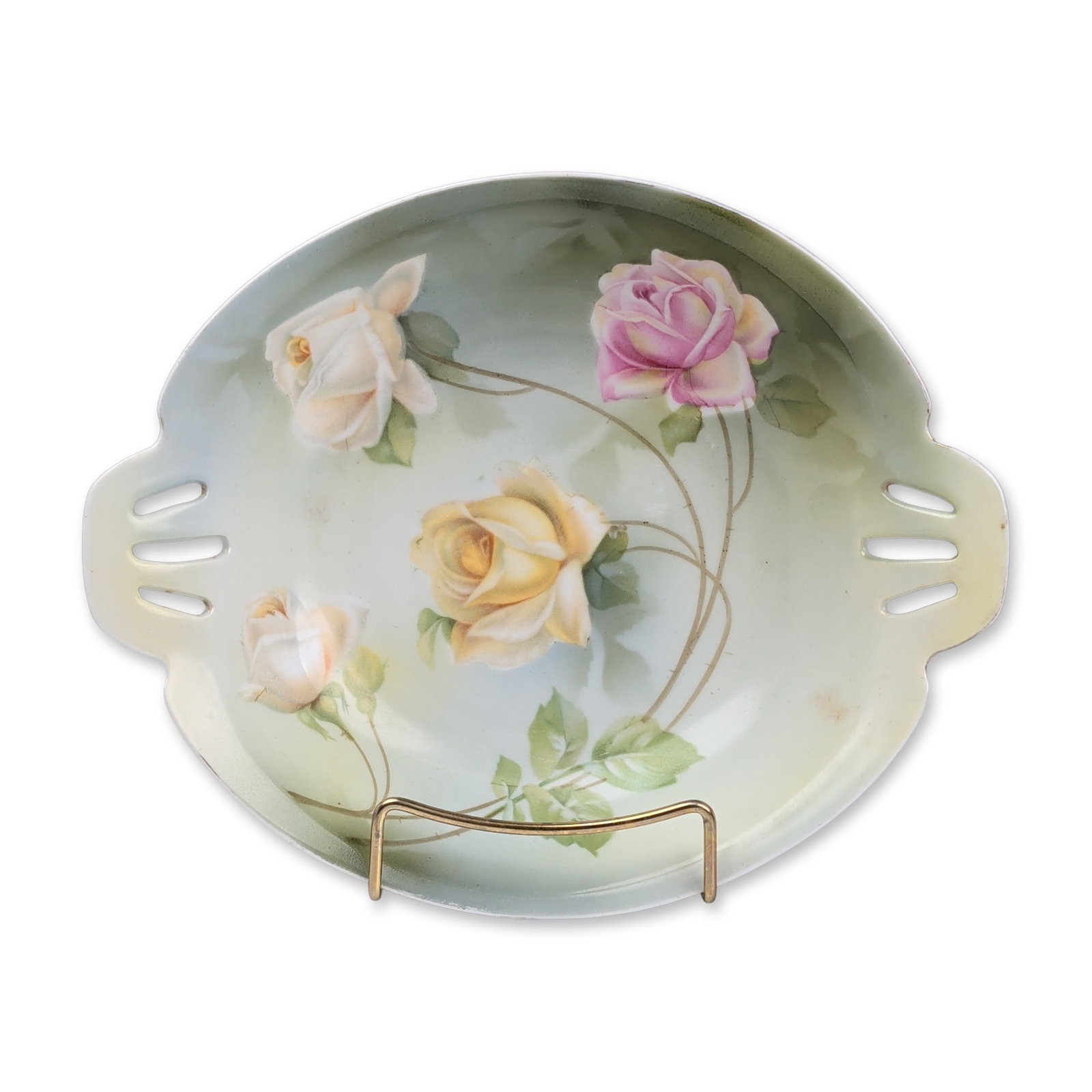 RS Germany Porcelain Hand Painted Floral Pierced Bowl: German porcelain shallow oval bowl by Reinhold Schlegelmilch, featuring a hand-painted floral motif. The interior depicts a cluster of four roses in shades of pink, yellow, and cream with green foliag