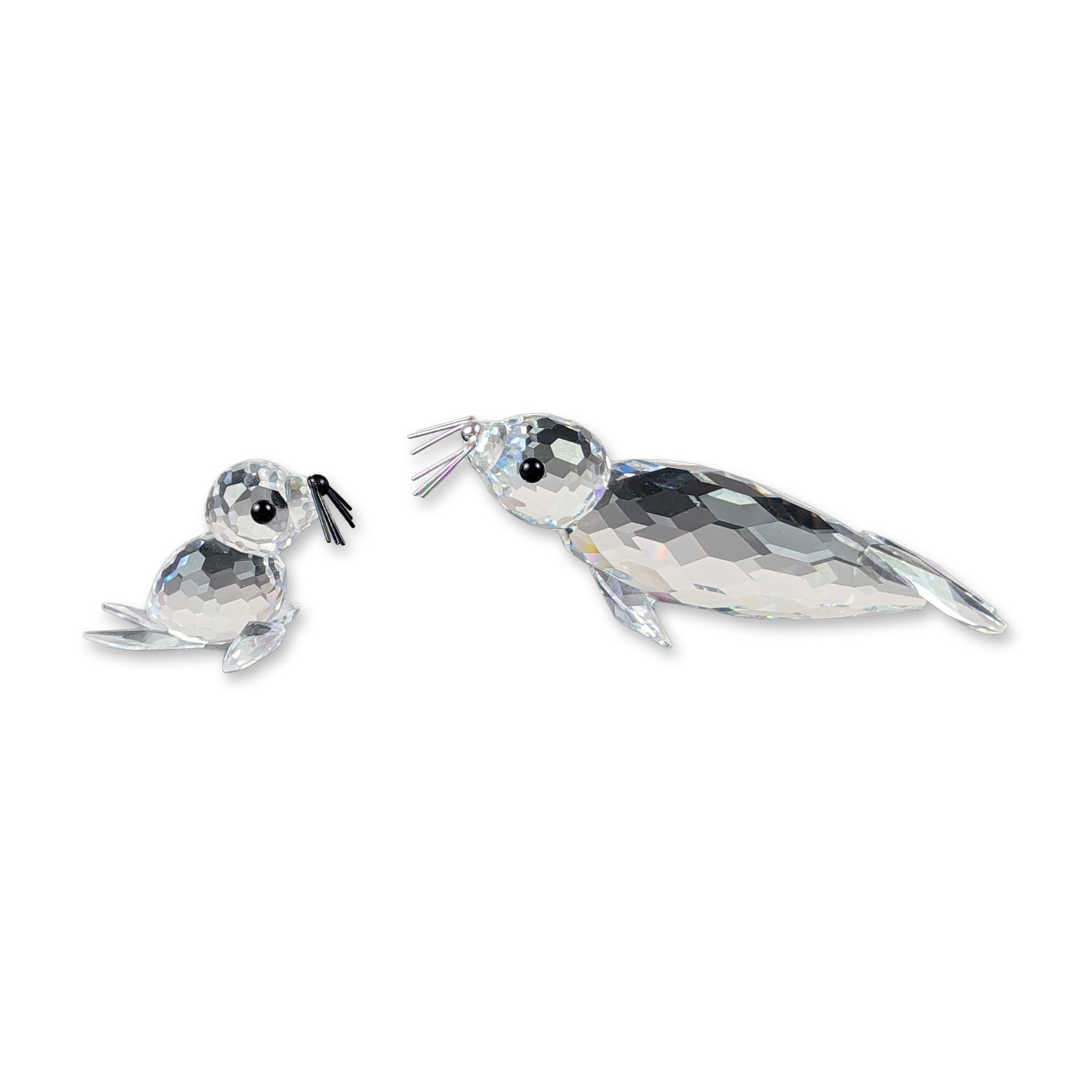 2pc Swarovski Silver Crystal Faceted Seal Figurines: This crystal pair features two marine wildlife specimens from the Swarovski Silver Crystal line, depicting an adult seal and pup. Each piece is crafted from transparent full lead crystal with precisio