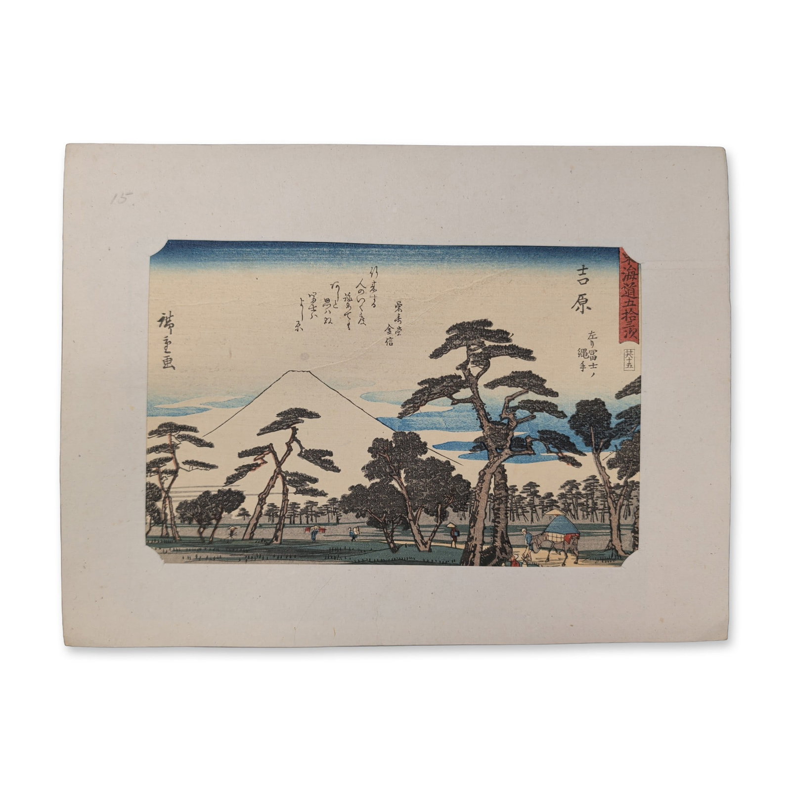 After Utagawa Hiroshige (Japanese 1797-1858) Yoshiwara, Fifty-Three Stations of the Tokaido: A horizontal format landscape composition centers on the snow-capped peak of Mount Fuji framed by pine trees in the foreground. Travelers and agricultural elements are visible along an embankment path