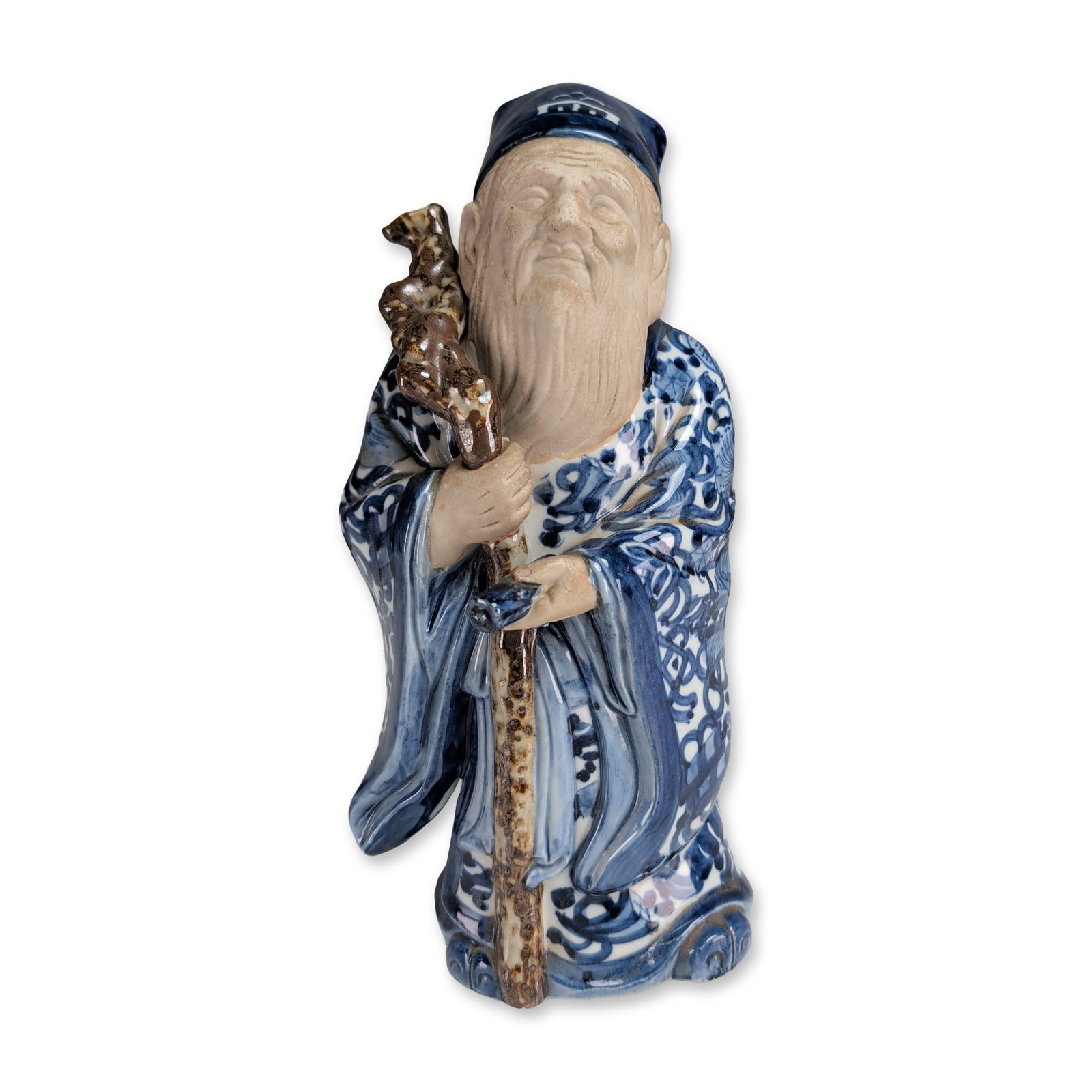 Japanese Blue and White Porcelain Jurojin Figurine: Japanese porcelain figurine of Jurojin, the god of longevity, featuring underglaze blue and white robes decorated with lotus scroll and geometric motifs. The figure is rendered with a matte, unglazed 