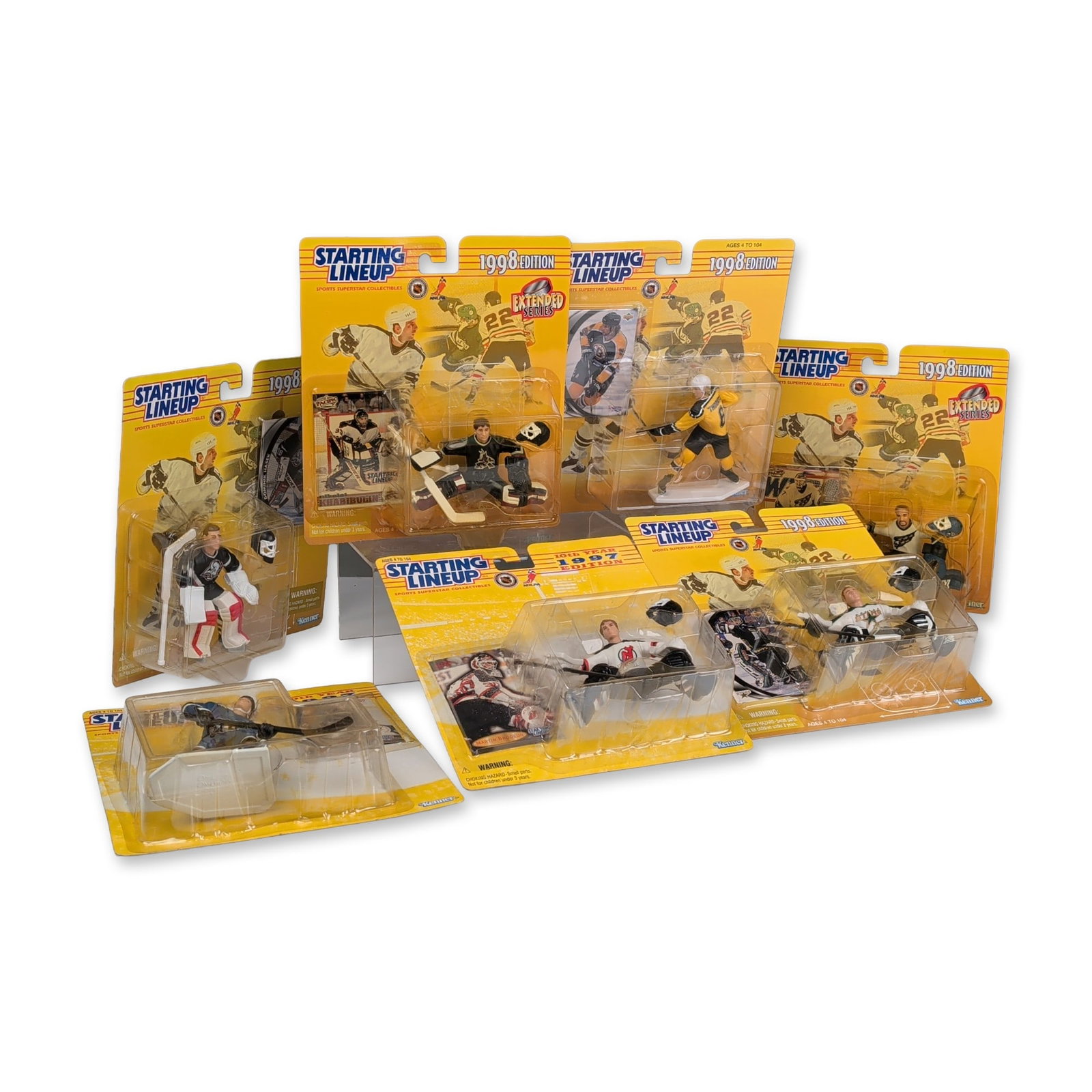 7pc Kenner 1997-1998 NHL Starting Lineup Action Figure Collection: A collection of seven vintage NHL hockey action figures produced by Kenner, each in its original factory-sealed blister card packaging. The assortment includes figures from the 1997 and 1998 editions,