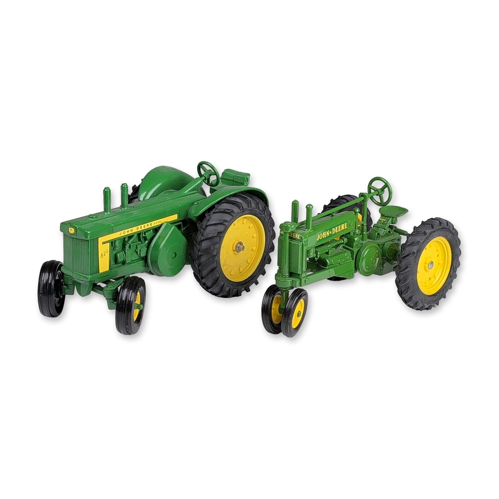 Two Ertl John Deere Die-Cast Tractor Replicas: Ertl (Dyersville, Iowa). Pair of John Deere toy tractors in die-cast metal, including a Model 820 Diesel and a Model GP. Each tractor is finished in green and yellow paint with rubber tires. The Model
