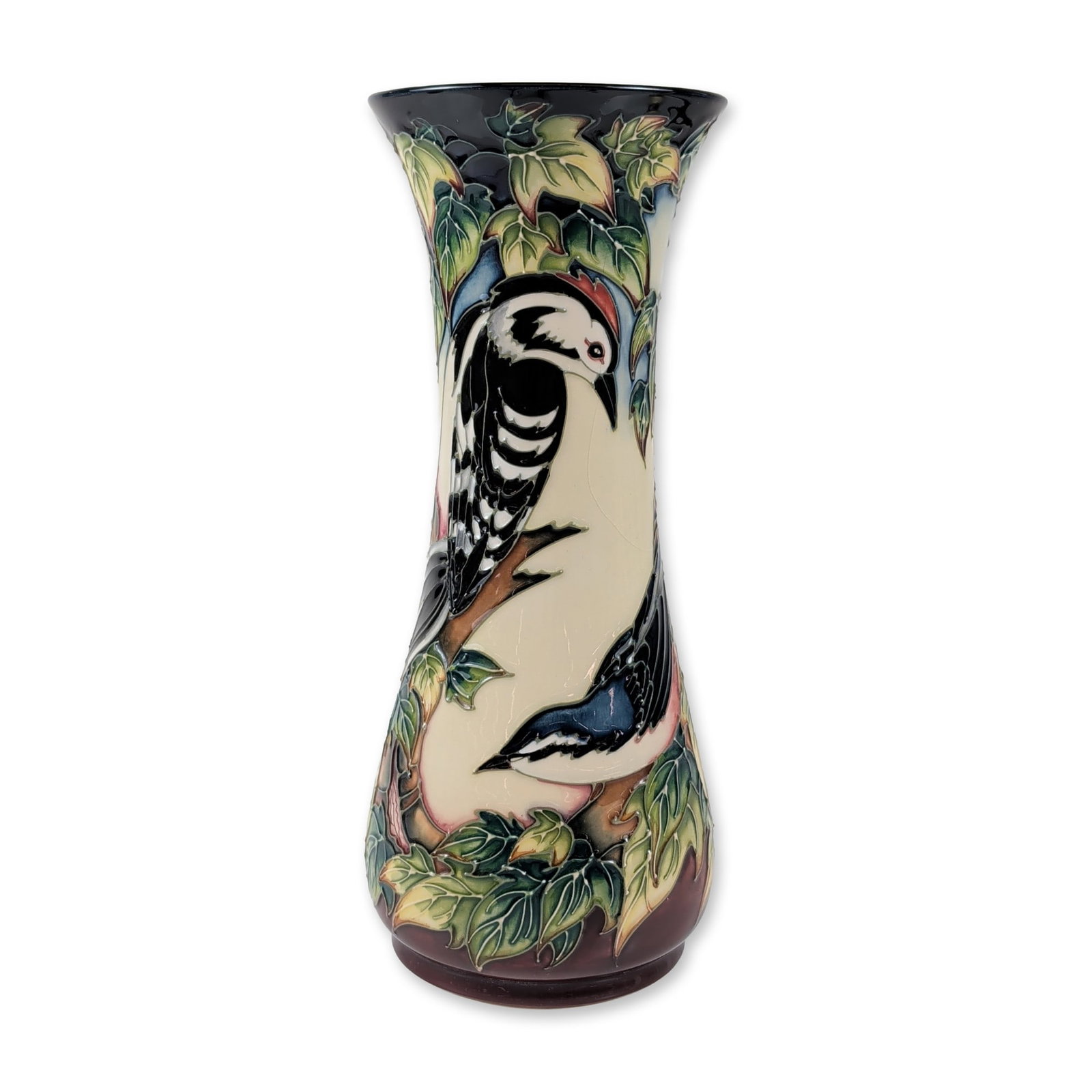 Moorcroft Philip Gibson Inglewood Ceramic Vase: This Moorcroft Pottery earthenware vase from Stoke-on-Trent, England, features the Inglewood pattern by Philip Gibson. Its tall shape, with a flared rim and rounded base, is decorated using a
