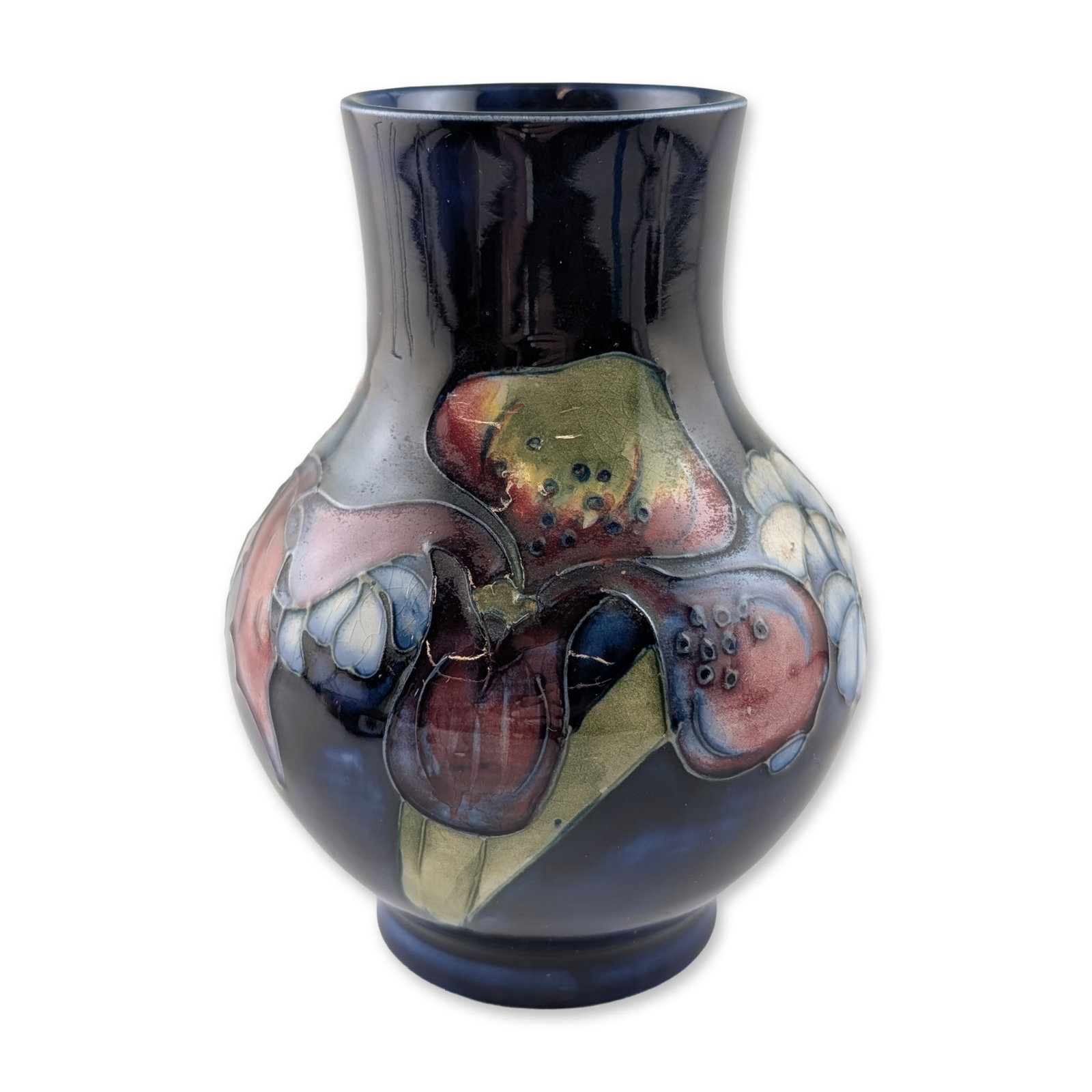 Moorcroft Slipper Orchid Pattern Cobalt Blue Pottery Vase: Moorcroft Pottery (England), circa 1940s-1950s. Earthenware vase of bulbous form featuring a flared neck and a low circular foot. The body is finished in a dark cobalt blue glaze and decorated with a 
