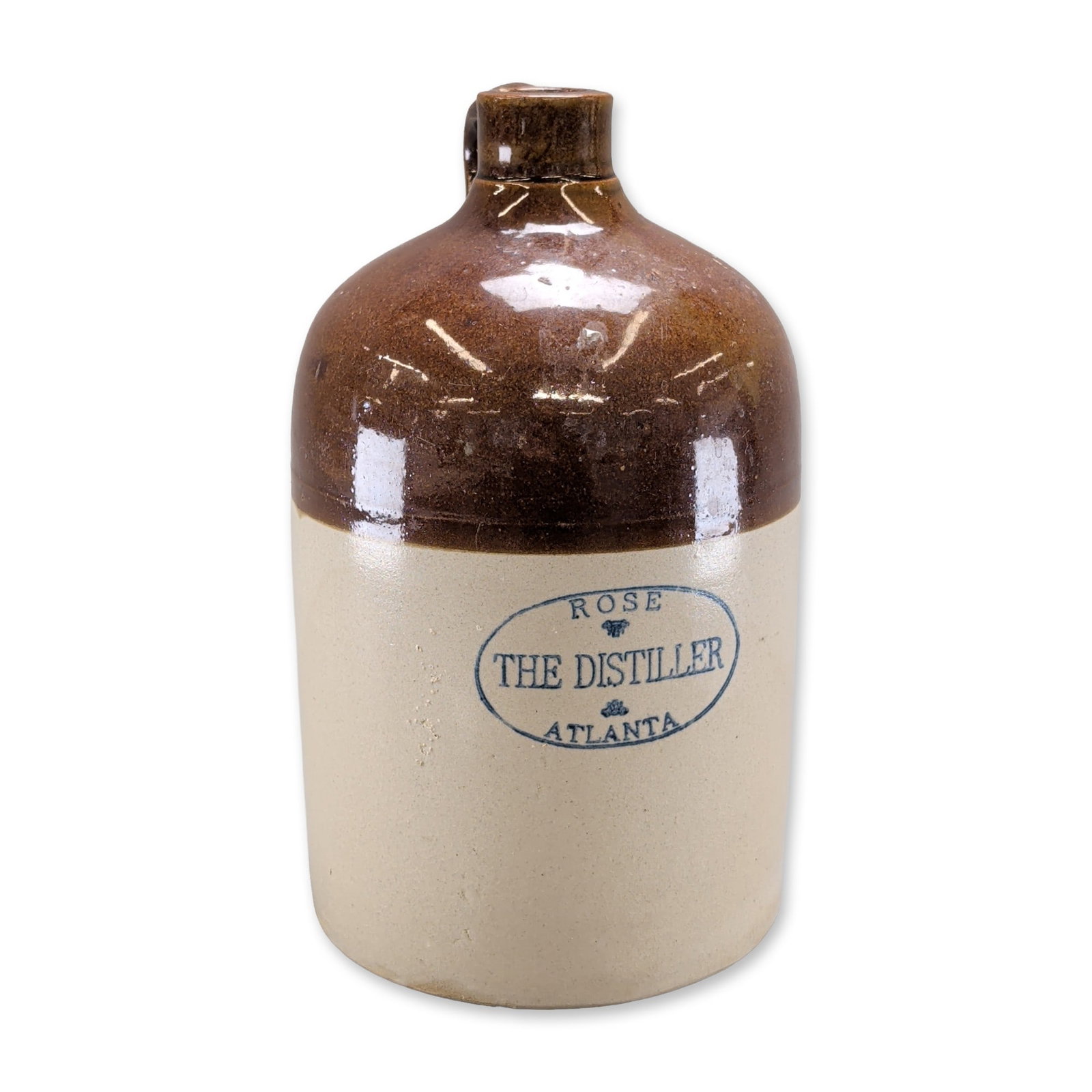 R. M. Rose Atlanta Stoneware Advertising Jug: American stoneware advertising jug, late 19th to early 20th century, with a two-tone glaze. The vessel features a cylindrical body with a rounded shoulder and a single strap handle. The upper section 