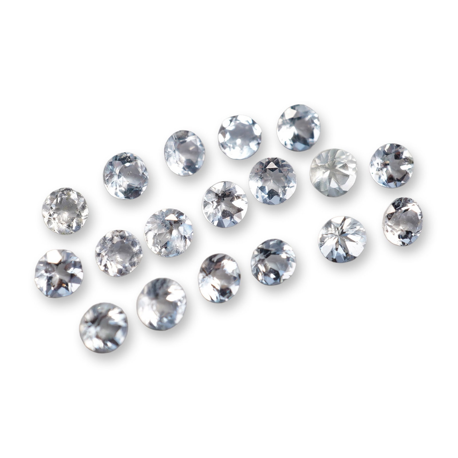 18pc Loose Round Cut Aquamarine Gemstones: Set of eighteen loose gemstones appearing to be aquamarine. Each stone features a pale icy blue hue and faceted round-cut construction. The gemstone exhibits colors similar to aquamarine, and testing 