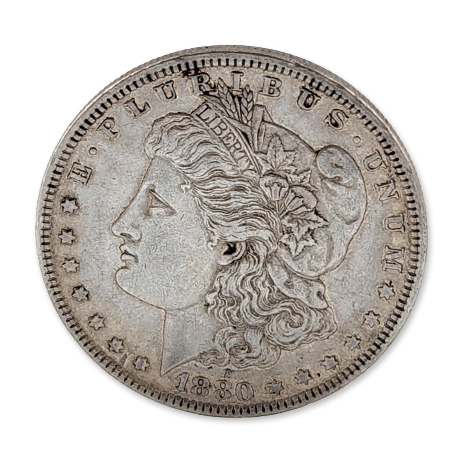 1880 US Morgan Silver Dollar Coin: US 1880 Morgan silver dollar struck at the Philadelphia Mint. Composed of 90% silver, the obverse features the George T. Morgan design of Lady Liberty in profile facing left. The reverse depicts a her
