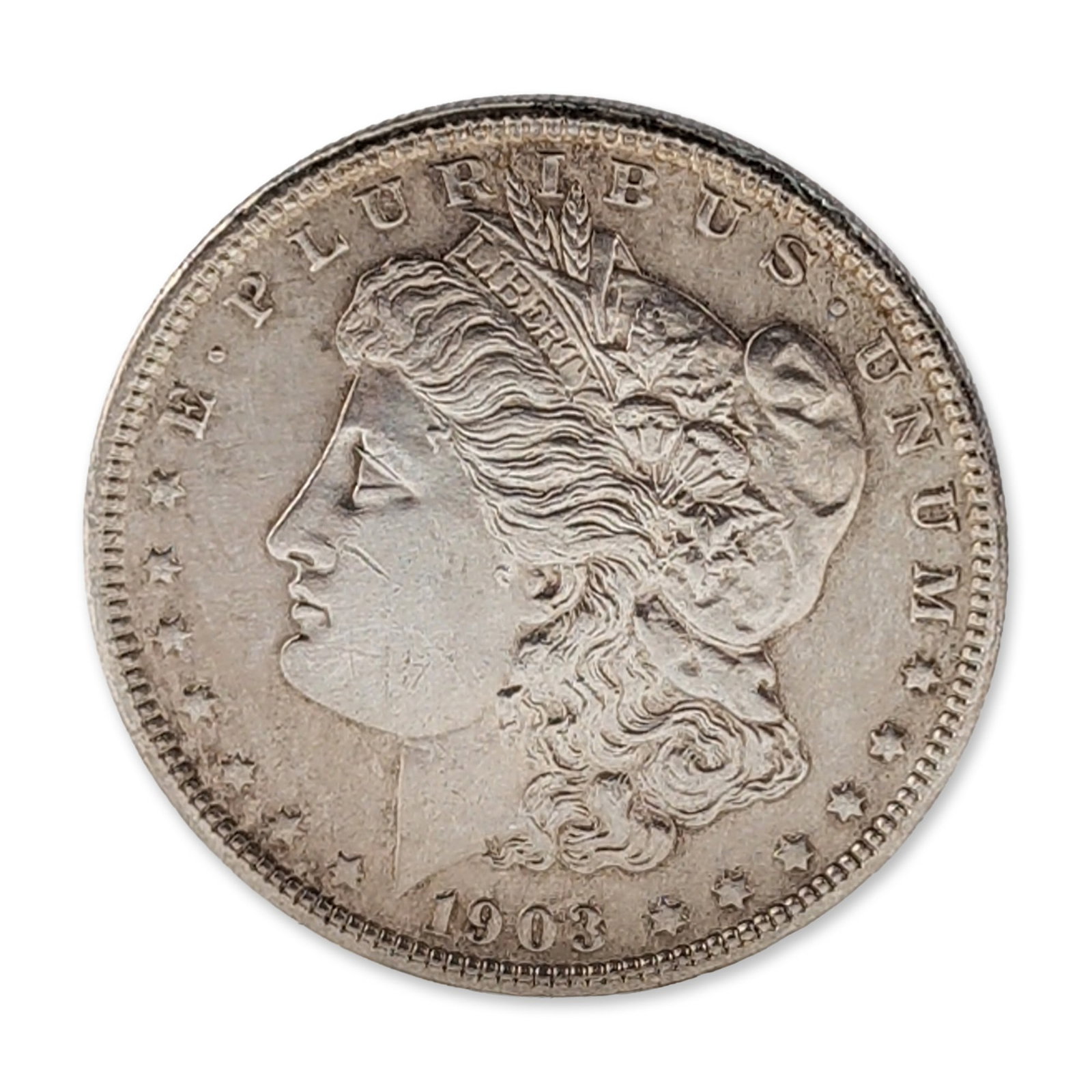 1903 US Morgan Silver Dollar Coin: US 1903 Morgan silver dollar. One dollar coin composed 0.900 fine silver and 0.100 copper. Obverse features a Liberty head profile dated 1903. Reverse depicts a heraldic eagle with outspread wings clu