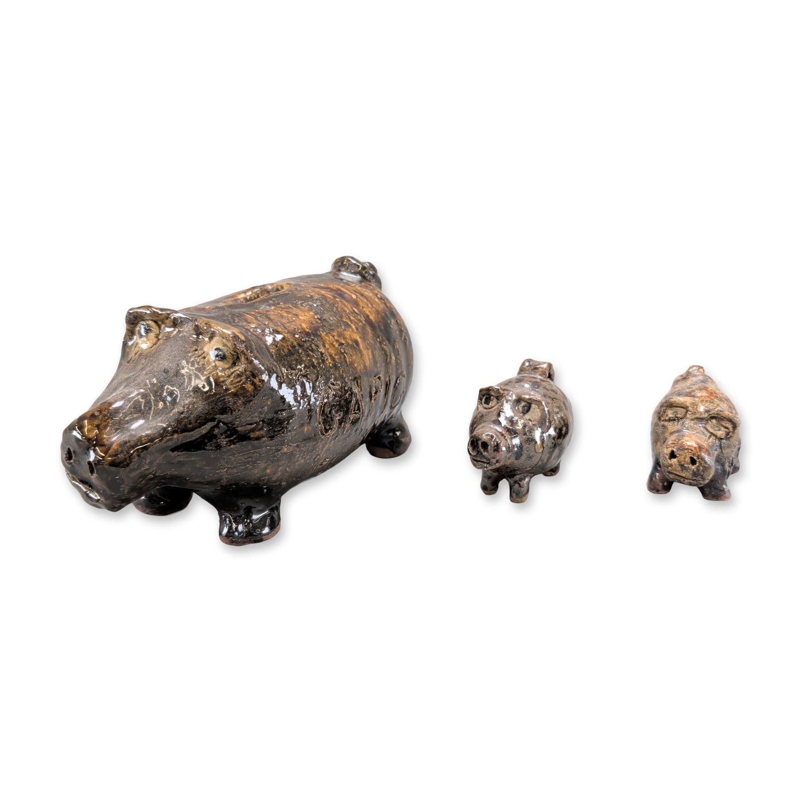 3pc Marie Rogers Pottery Piggy Bank and Figurines: Trio of hand-modeled stoneware pig figurines by Marie Rogers (Gillsville, Georgia, 1922-2010), comprising one large bank and two smaller piglets. The pieces are finished in a characteristic high-gloss
