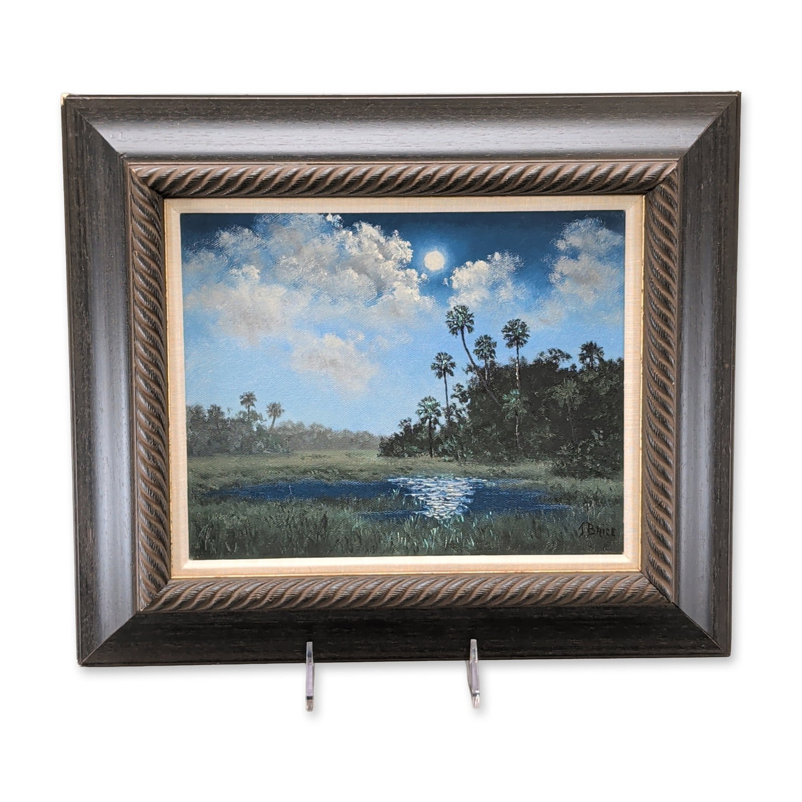 Jacqueline Brice (American, b. 1935) Florida Nocturnal Landscape Oil on Canvas: Florida school landscape painting in oil on canvas depicting a nocturnal marsh scene with a cluster of palm trees, dark foliage, and a small pool of water reflecting moonlight. The composition feature