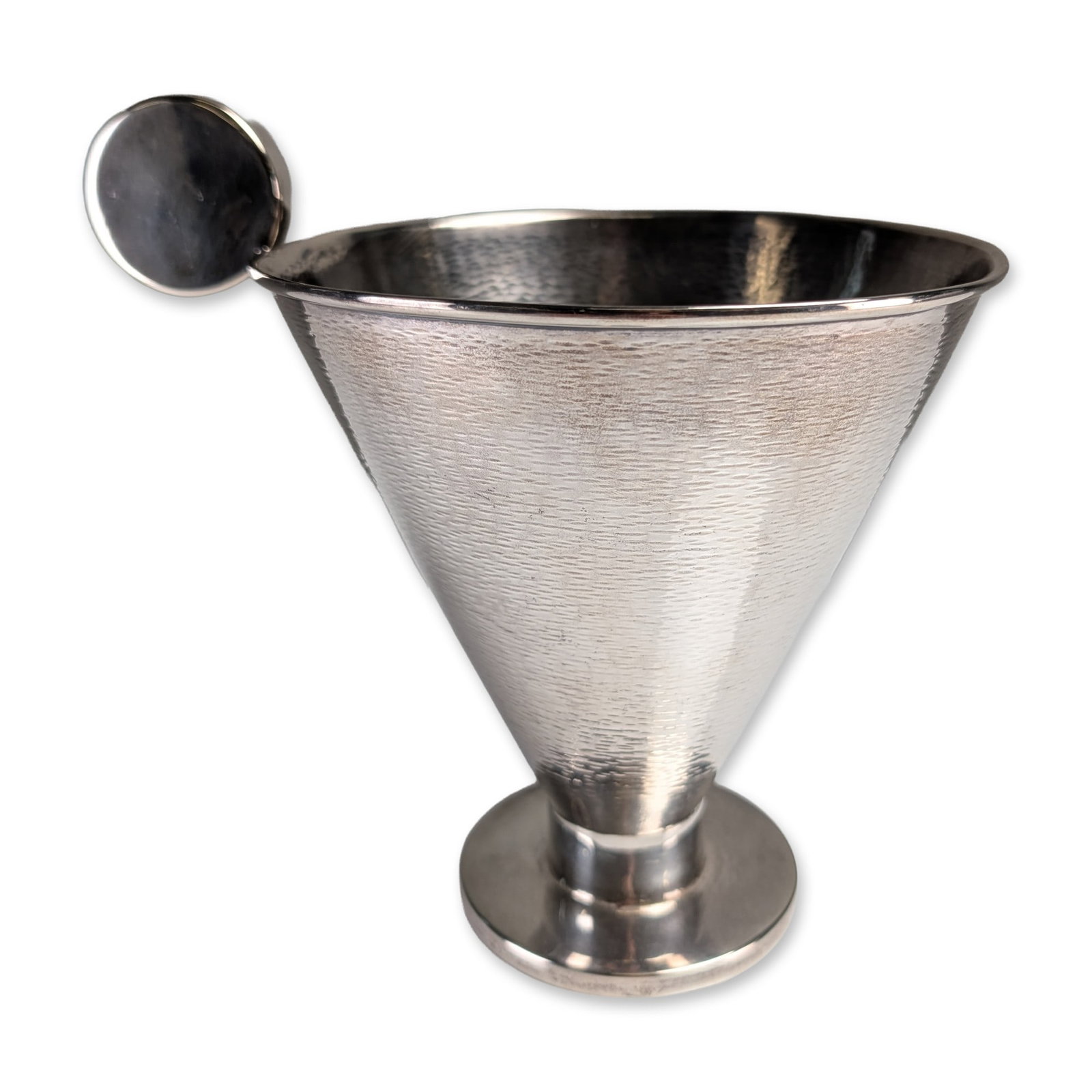 Modernist Solid Silver Martele and Sleek Disk-Handle Bowl: Modernist solid silver bowl featuring a conical shape with a horizontally oriented hammered texture. The piece incorporates a smooth flat circular disk handle joined to the rim, a short cylindrical