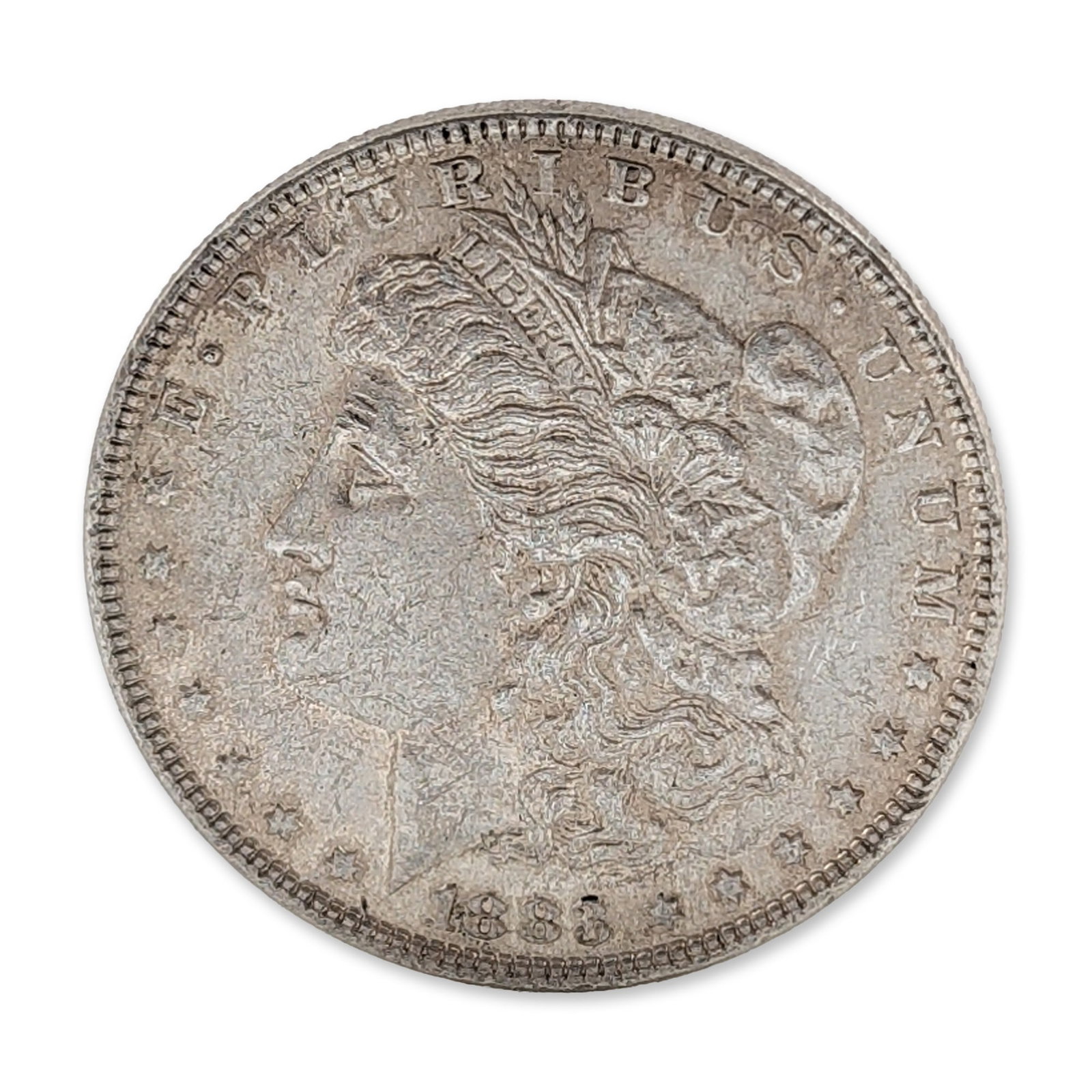 1883 US Morgan Silver Dollar Coin: 1883 US Morgan silver dollar struck at the Philadelphia Mint. Composed of 90 percent silver and 10 percent copper. The obverse features a left-facing profile of Liberty wearing a Phrygian cap inscribe