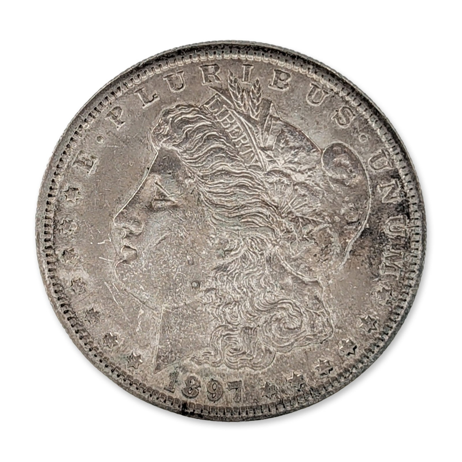 1897-S US Morgan Silver Dollar Coin: US Mint. 1897-S Morgan silver dollar, composed of 90% silver. The obverse features a left-facing profile of Liberty wearing a Phrygian cap with floral decorations and a headband inscribed LIBERTY, bor