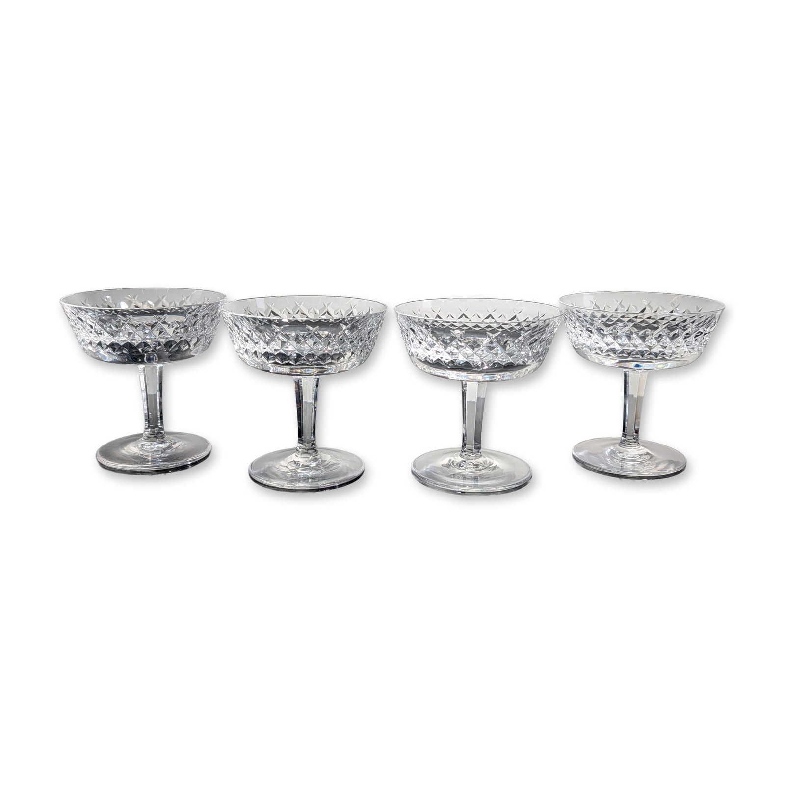 4pc Waterford Alana Crystal Champagne/Sherbet Coupes: Waterford Crystal set of four champagne or sherbet coupes in the Alana pattern, crafted from hand-cut crystal. Each vessel features a wide, shallow bowl decorated with a dense band of deep cross-cut d