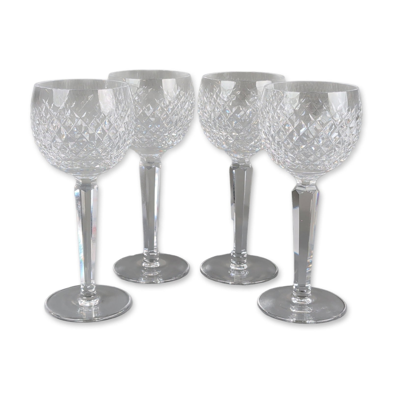 4pc Waterford Alana Cut Crystal Wine Glasses: Waterford (Ireland). A set of four wine glasses in cut lead crystal, featuring the Alana pattern with diamond-cut criss-cross bowls and faceted hexagonal stems. The underside of the foot bears a faint