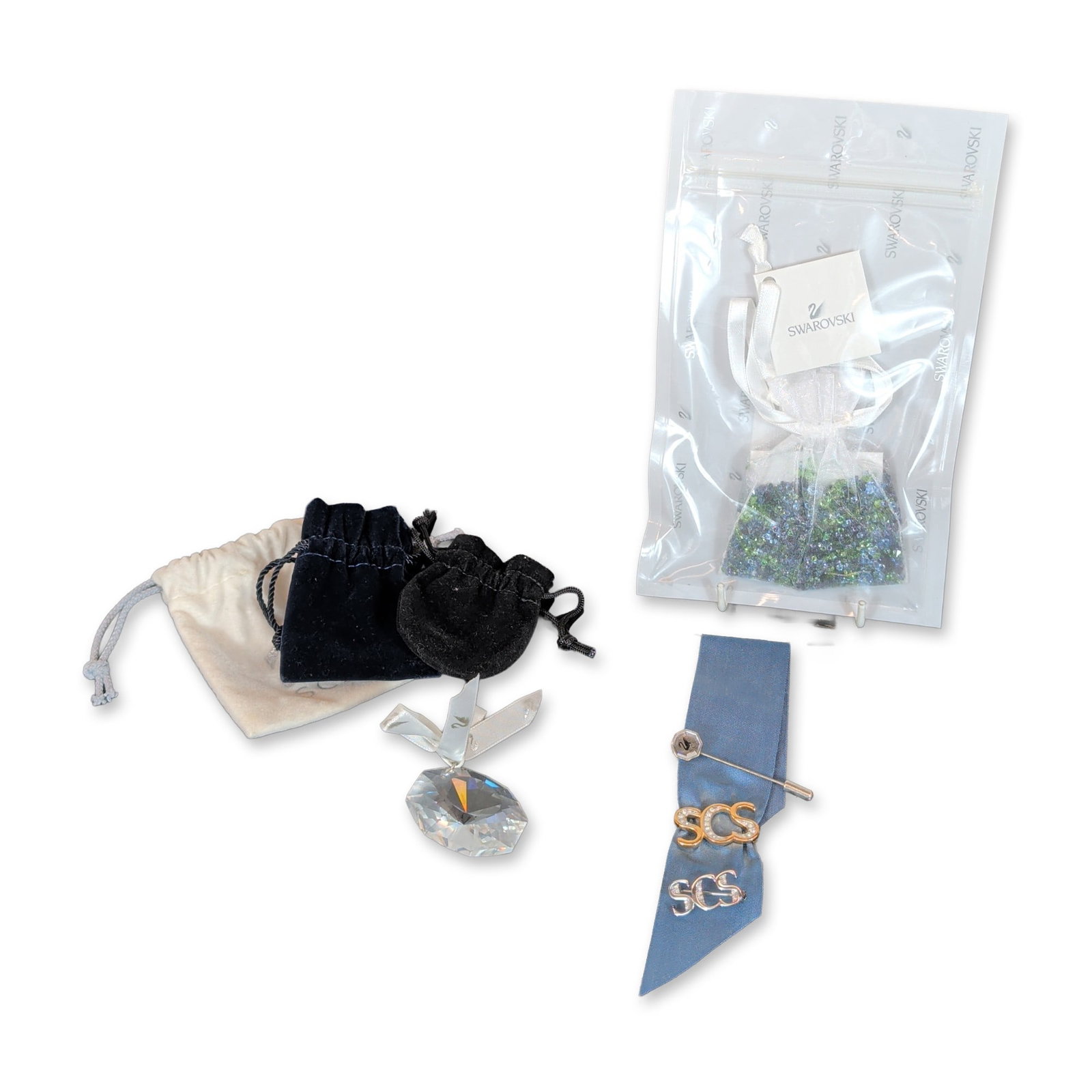 5pc Swarovski Crystal Society SCS Pins and Crystals: Collection of memorabilia and jewelry components, including three pins displayed on a blue ribbon: a silver-tone stick pin with a swan logo terminal, a gold-tone SCS script pin accented with pave crys