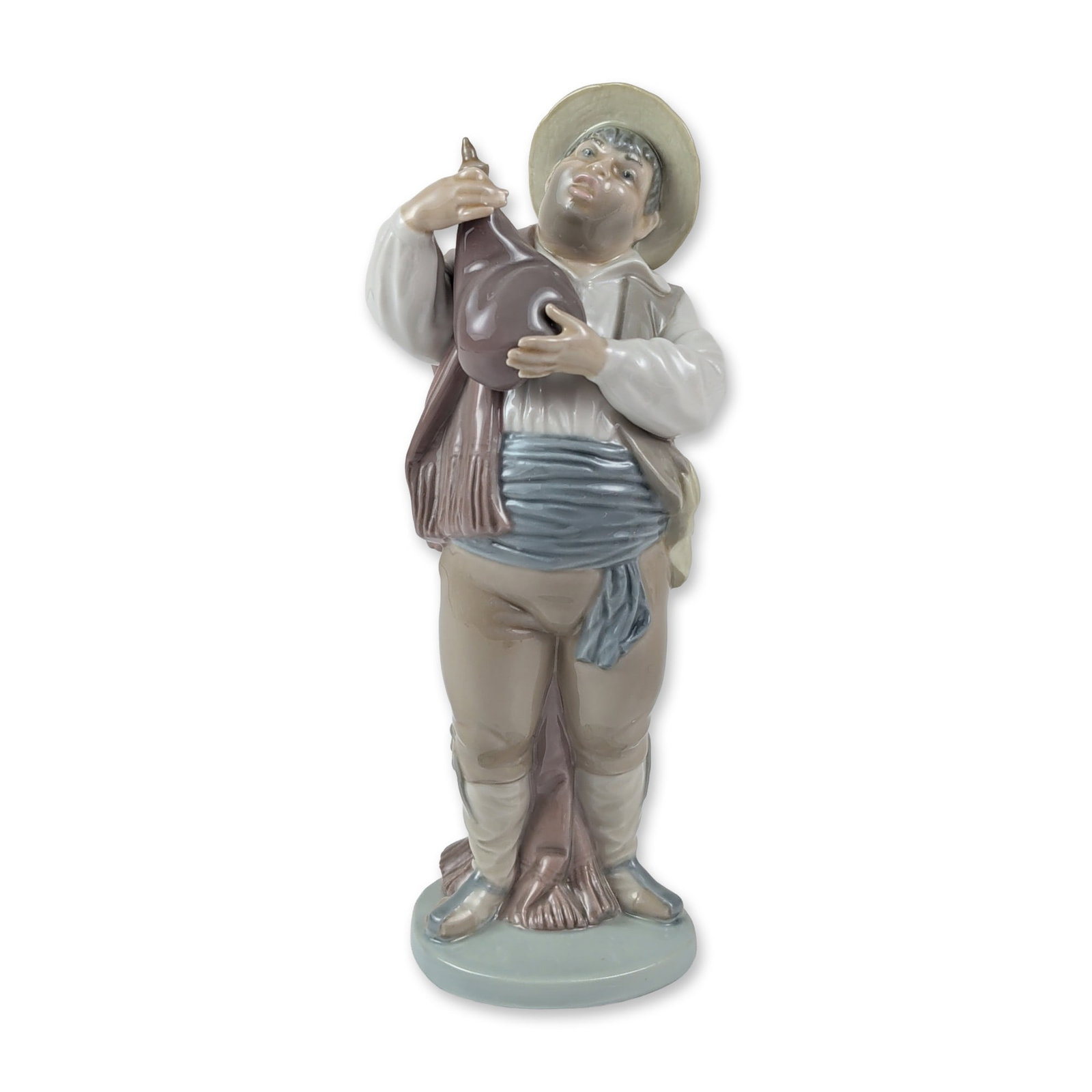 Lladro Porcelain Figurine, A Toast by Sancho 1005165: Spanish Lladro glazed porcelain figurine titled A Toast by Sancho, depicting a man in traditional folk attire with a straw-colored hat, white shirt, brown vest, and blue sash. He is modeled holding a 