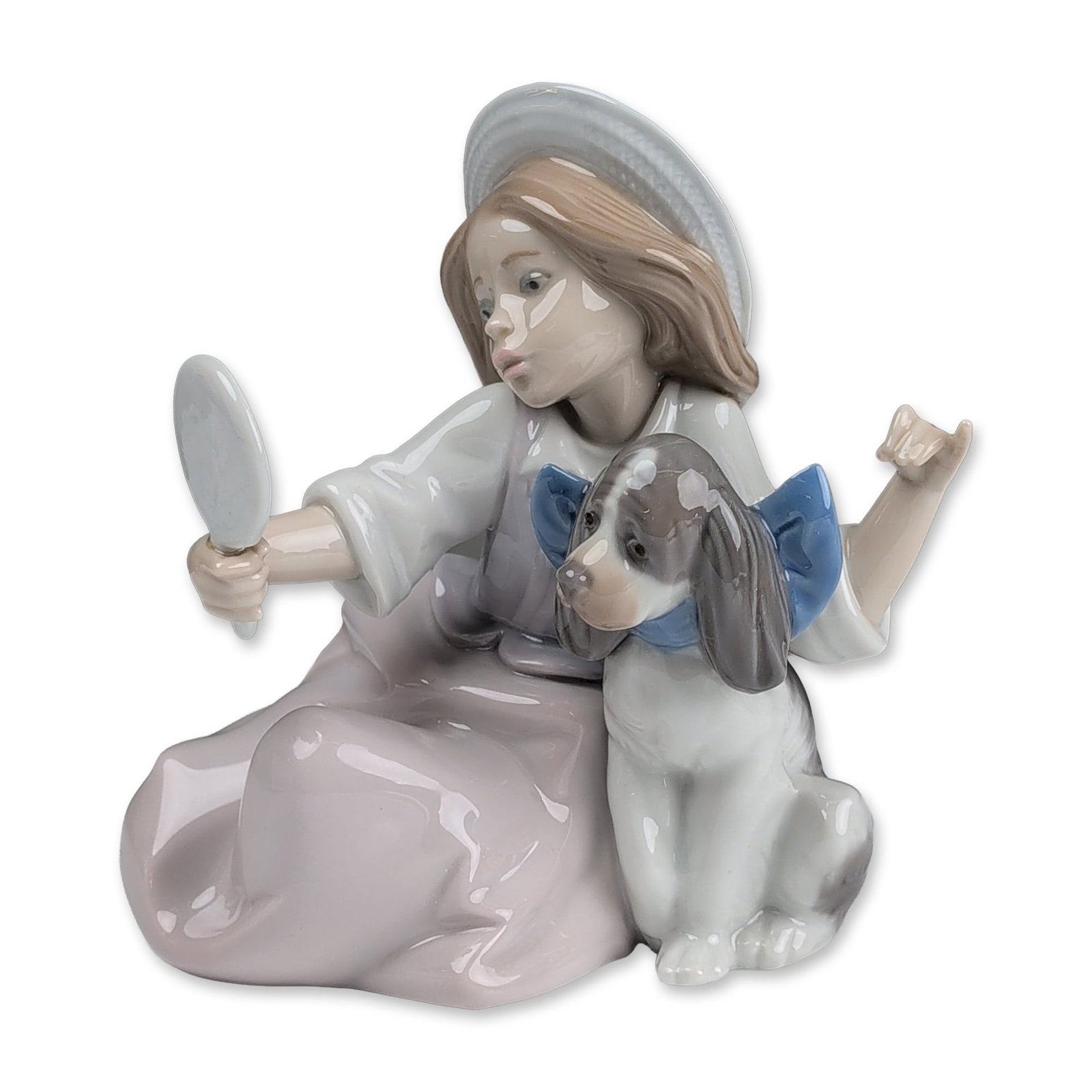 Lladro Porcelain Figurine, Who Is The Fairest? 01005468: Lladro glazed porcelain figurine produced in Valencia, Spain. The piece depicts a young girl kneeling in a lavender skirt and white blouse, wearing a wide-brimmed sunhat with a blue ribbon. She holds 