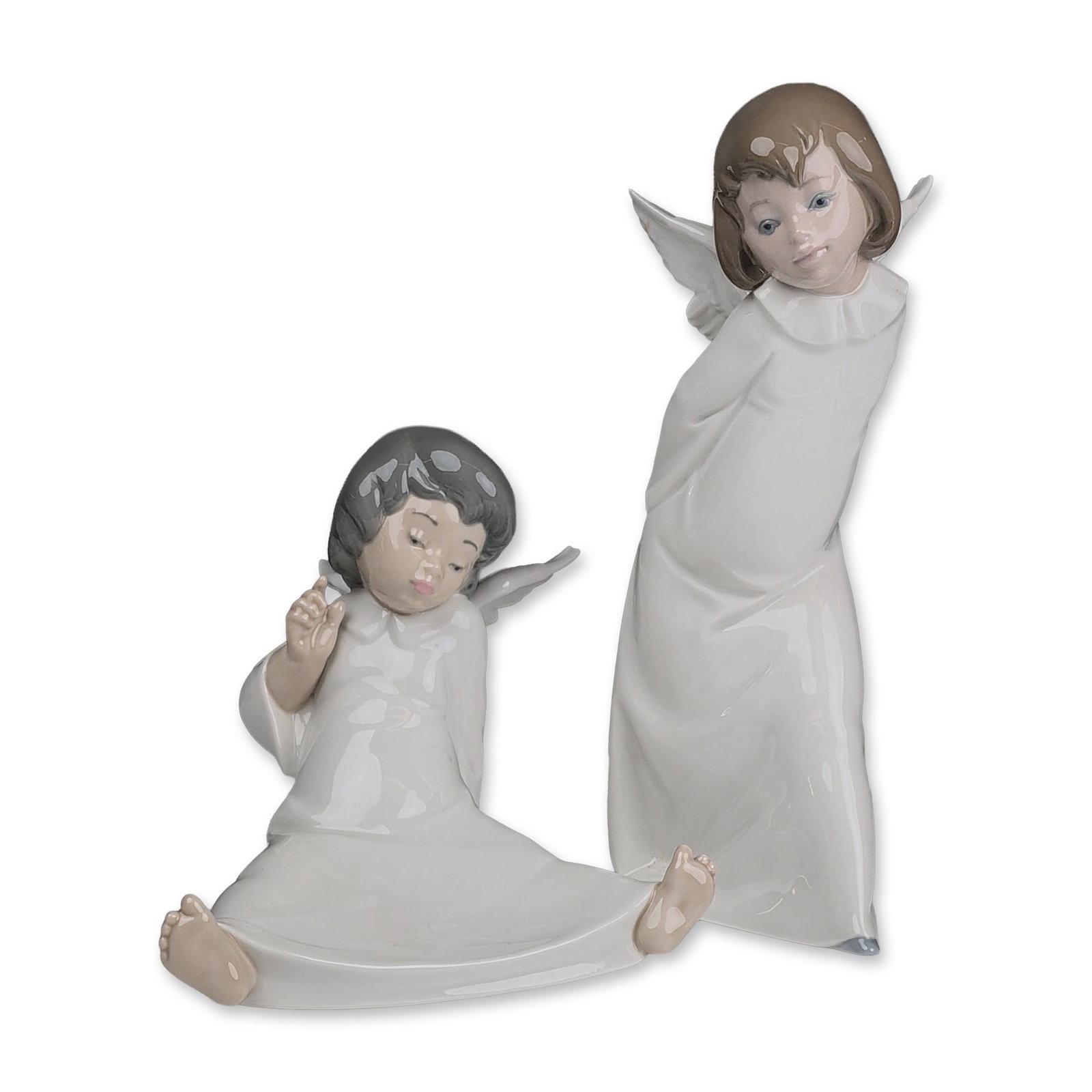 2pc Lladro Porcelain Figurines, Smiling Cherub 01004960 and Wondering Cherub 01004962: Two Spanish Lladro polychrome glazed porcelain figurines: Smiling Cherub (model number 01004960 / 4960) and Wondering Cherub (model number 01004962 / 4962). The first figure is a standing angel in a f