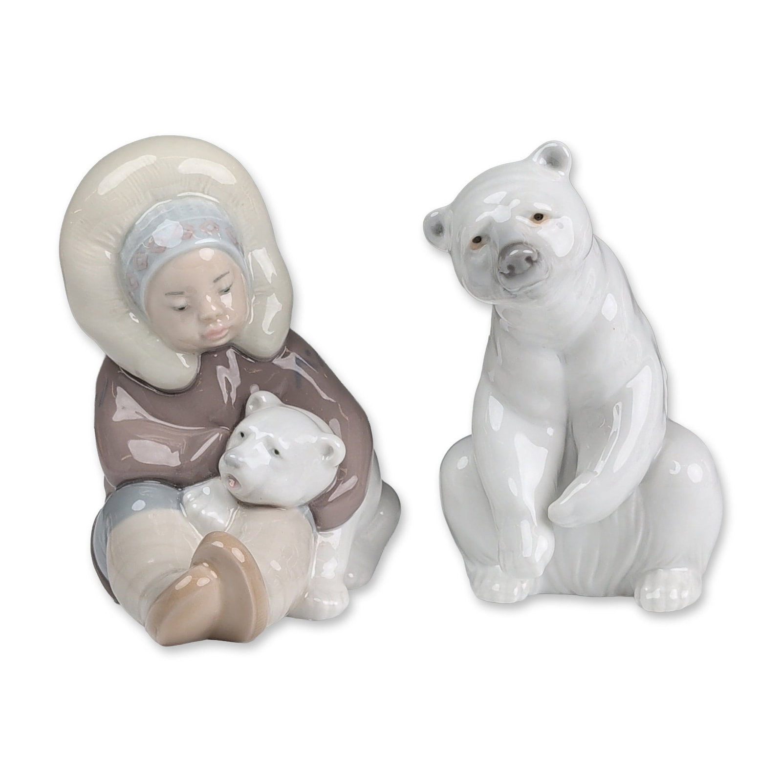 2pc Lladro Porcelain Arctic Figurines, Resting Polar Bear 01001208 and Eskimo 01001195: Lladro, Spain, late 20th century. Two glazed porcelain figurines with Arctic subjects. The lot includes one figurine of a seated Inuit child wearing a brown parka with cream fur-trimmed hood and boots