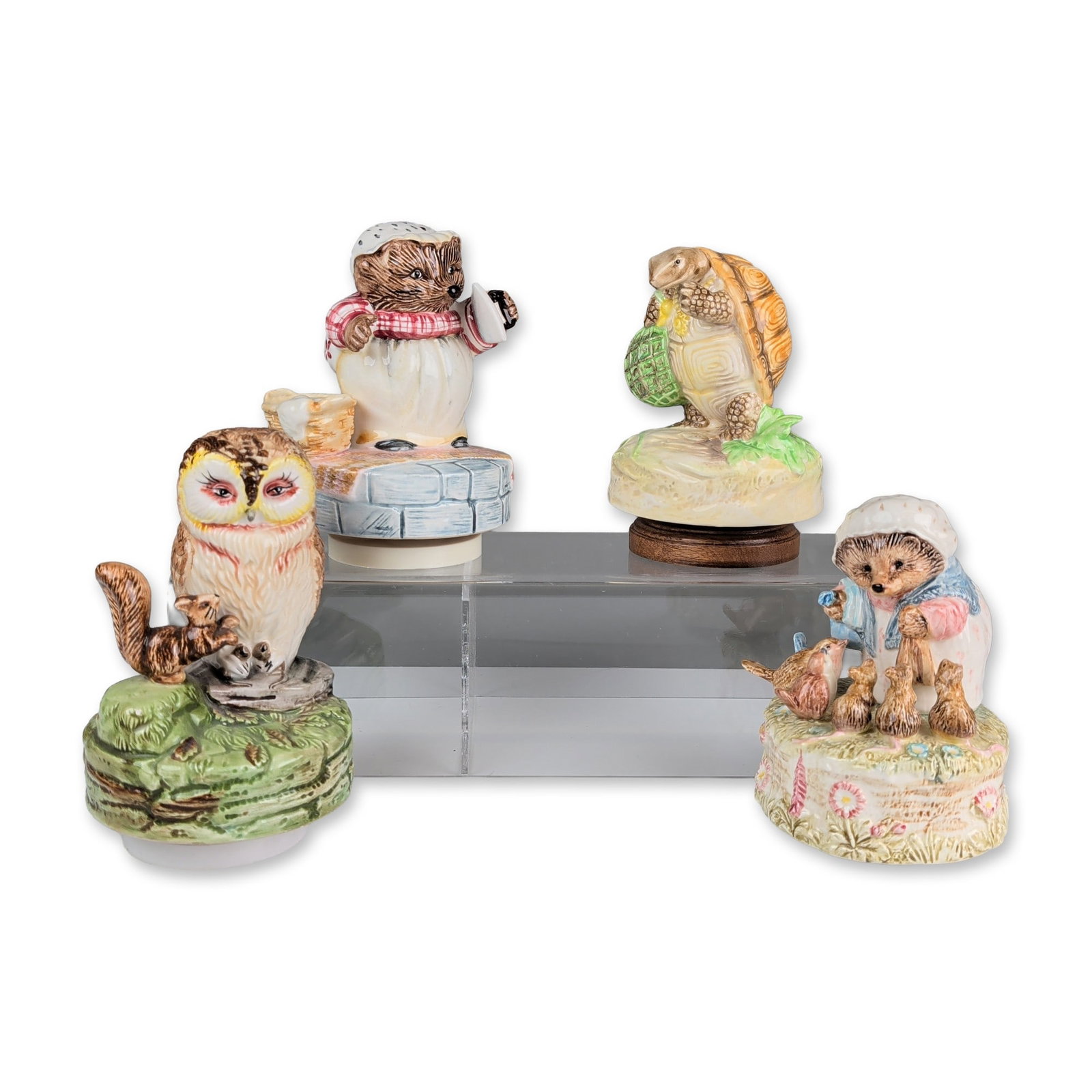 4pc Schmid Beatrix Potter Musical Ceramic Figurines: Collection of four Schmid musical figurines in hand-painted ceramic, featuring characters licensed by Frederick Warne and Co. The group includes a Mrs. Tiggy-Winkle figure holding a flat iron on a blu