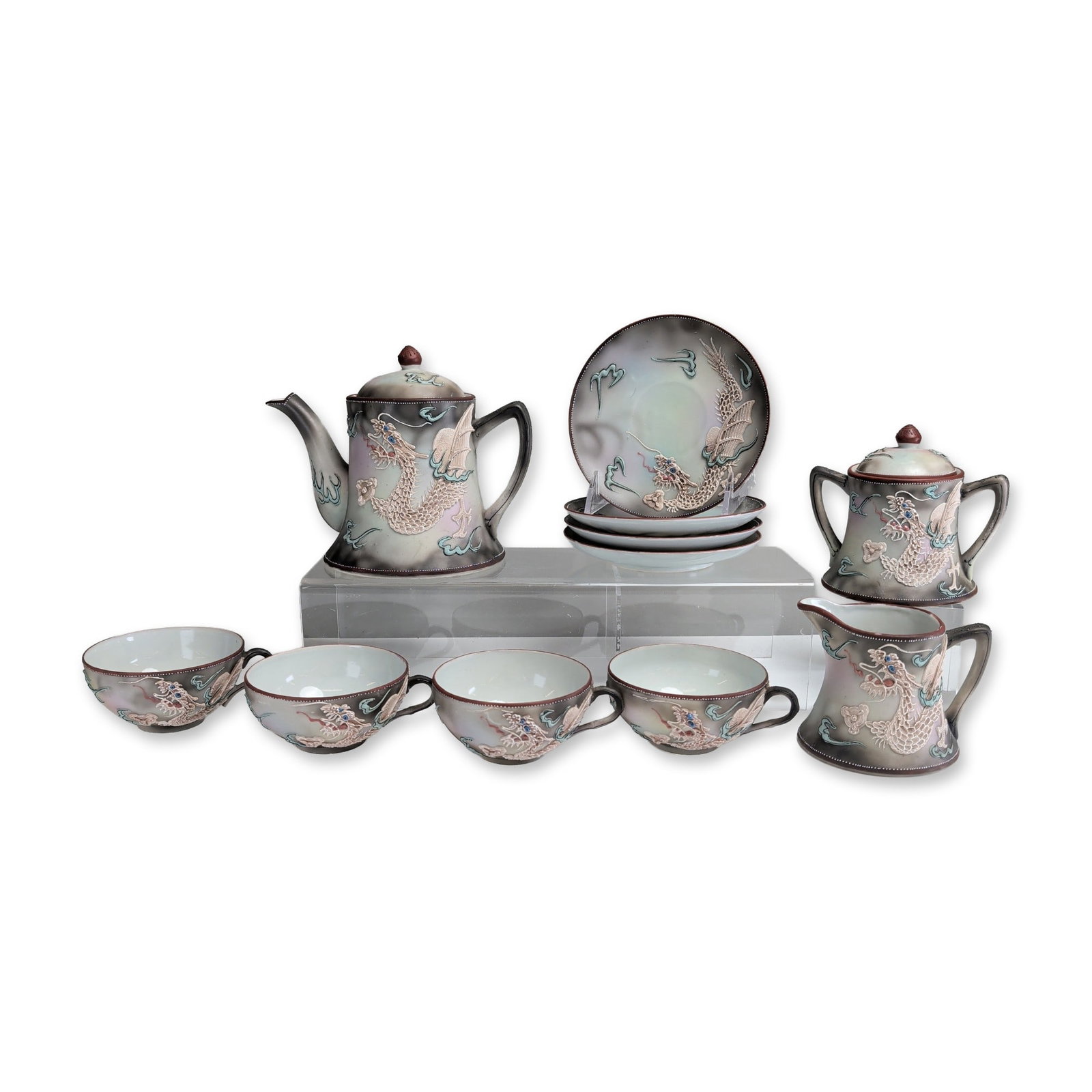 11pc Japanese Nippon Dragonware Moriage Porcelain Tea Set: An eleven pieces Japanese export porcelain tea set featuring hand-painted moriage decoration in a dragon in clouds pattern. Each piece displays a high-relief dragon with textured scales and blue jewel