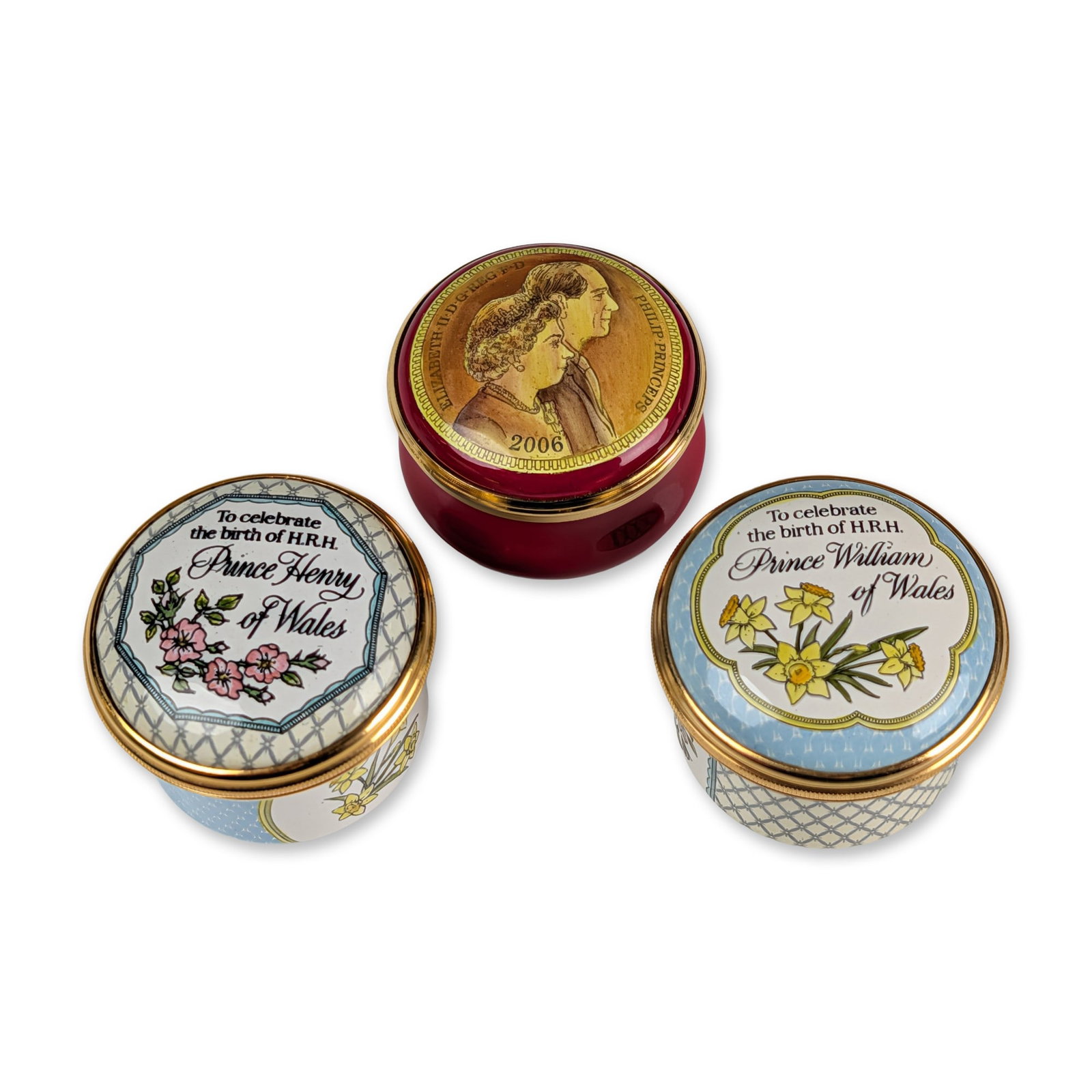 3pc Halcyon Days Royal Family Enamel Boxes: A trio of English commemorative enamel-on-copper lidded boxes by Halcyon Days, celebrating British Royal family milestones, featuring gilt metal mounts. The Prince William box (1982) features a lid wi