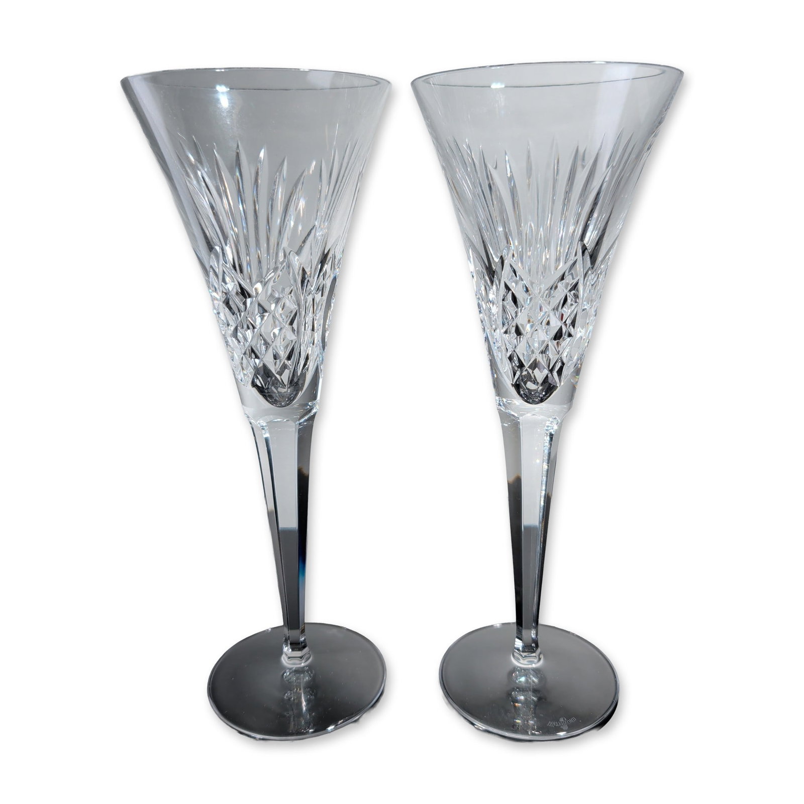 2pc Waterford Millennium Health Crystal Champagne Flutes: Waterford pair of champagne toasting flutes in lead crystal, part of the Millennium series in the Health pattern. The flutes feature trumpet-shaped bowls with diamond and vertical wedge cuts, faceted 