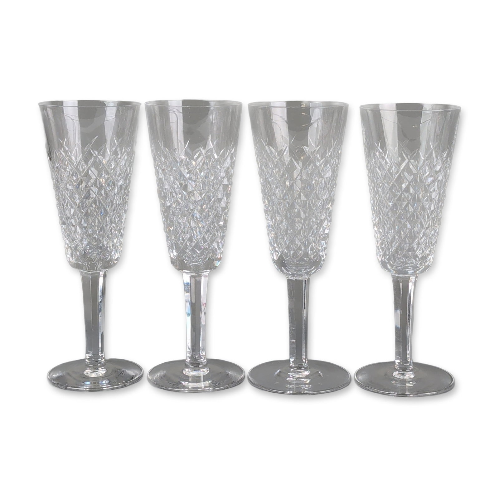 4pc Waterford Crystal Alana Champagne Flutes: Waterford. Set of four champagne flutes in lead crystal, in the Alana pattern, featuring trumpet-form bowls decorated with a field of deep-cut diamond patterns above faceted stems, each base bearing a