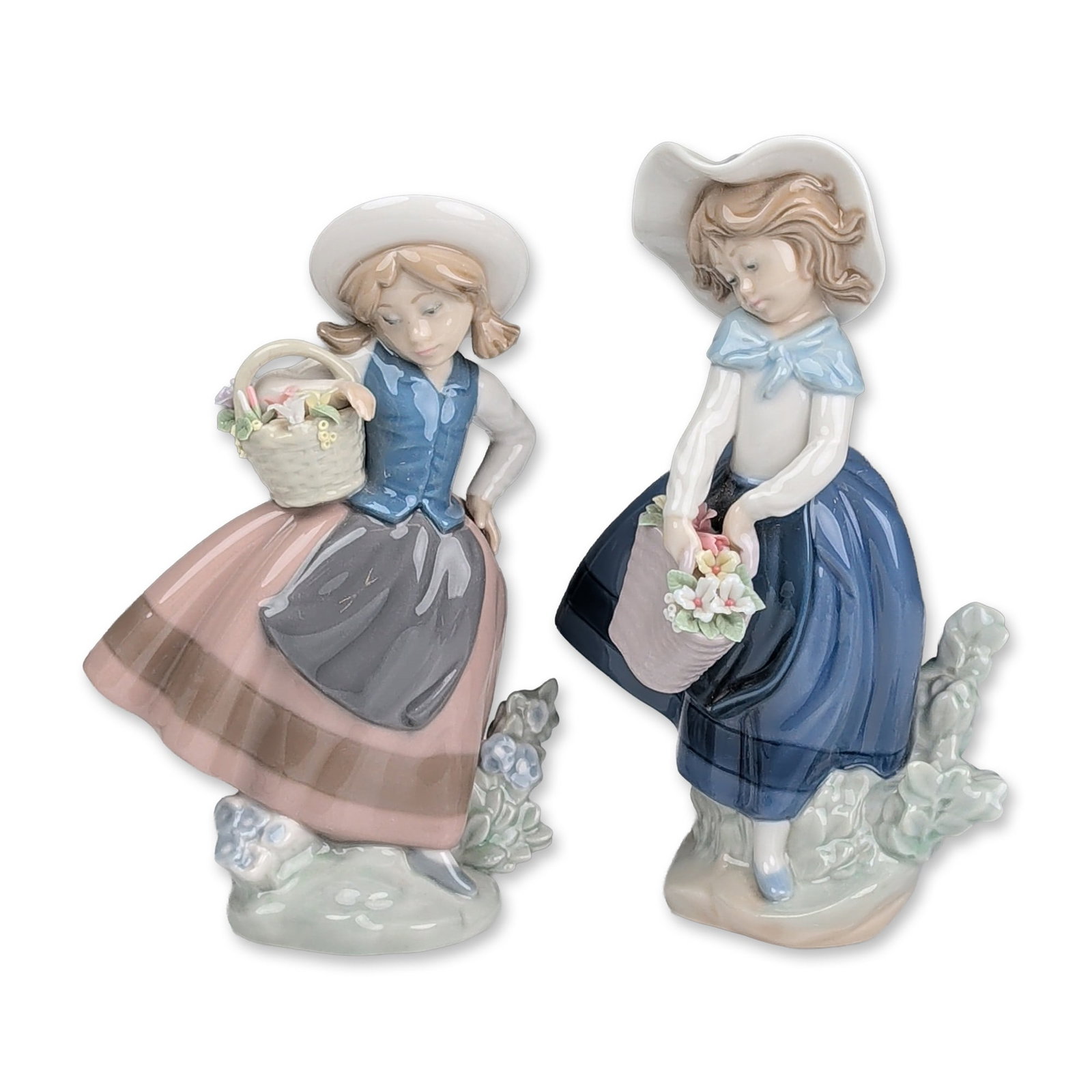 2pc Lladro Porcelain Figurines, Sweet Scent 01005221 & Pretty Pickings 01005222: Spanish, late 20th century. Pair of Lladro glazed porcelain figurines depicting pastoral scenes. One figurine represents model 5221, Sweet Scent, featuring a girl in a wide-brimmed white hat and dark 