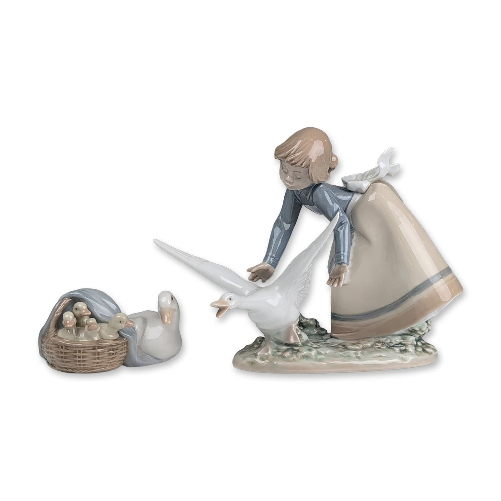 2pc Lladro Glazed Porcelain Figurine, Wild Goose Chase 01005553 & Ducks 01004895: Lladro (Spain) glazed porcelain figurine pair featuring rural avian themes. The larger figurine, Wild Goose Chase depicts a young girl in a blue long-sleeved shirt and beige skirt with a lace-trimmed 