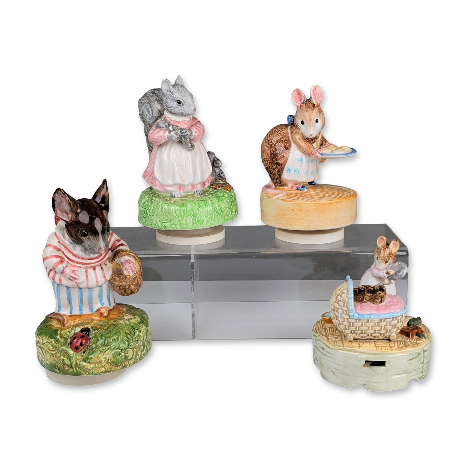 4pc Schmid Beatrix Potter Music Boxes: The set includes four hand painted figurines, each mounted on a mechanical wind-up base. One figure depicts a squirrel in a pink dress and white apron, with the base side printed Schmid and the revers