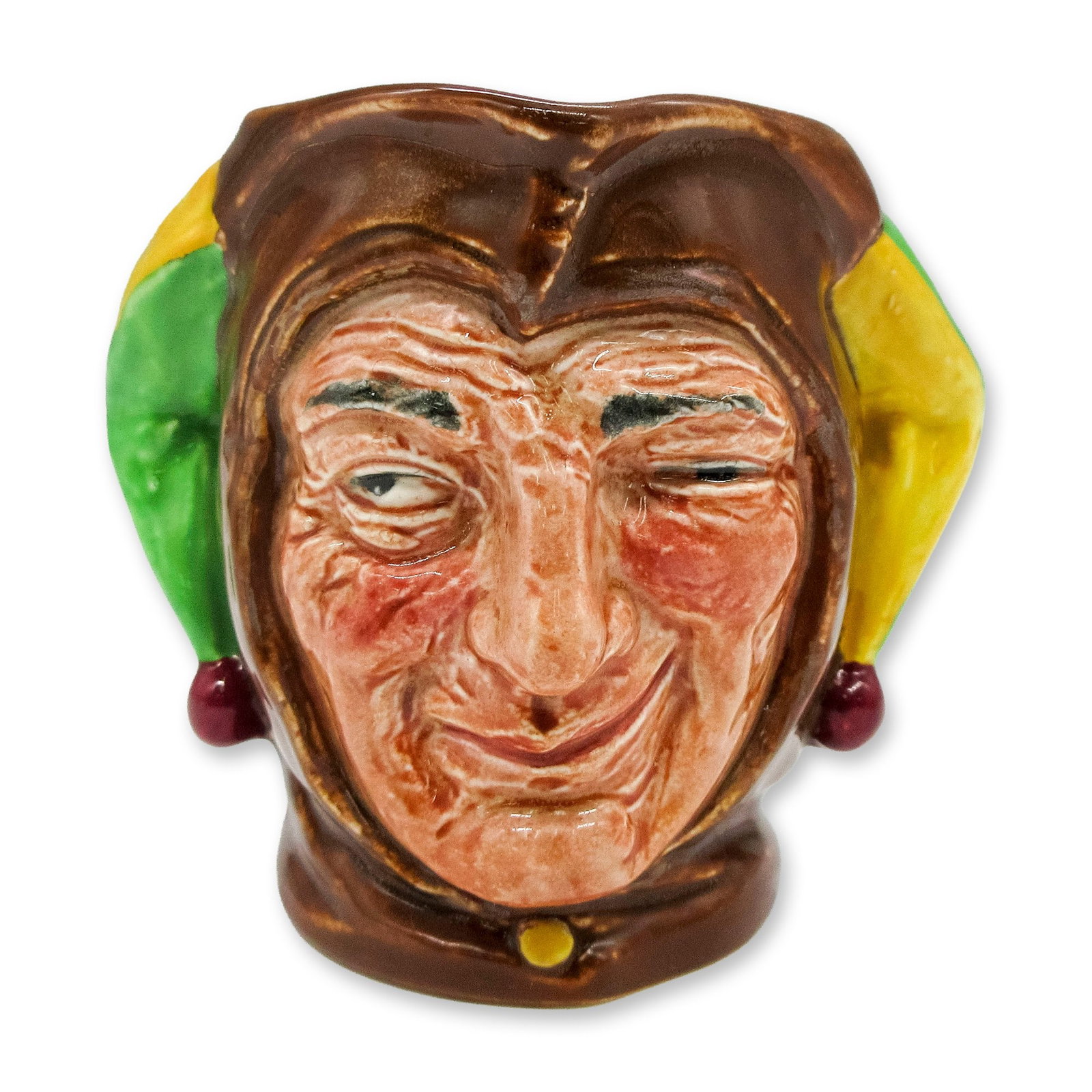 Jester D5556 - Small - Royal Doulton Character Jug: Glossy figural with green and yellow coloration on either side of the hat may be reversed as a preference of the painter. Royal Doulton backstamp. Artist: Charles Noke Dimensions: 3.5"L x 4"W x 3"H Da
