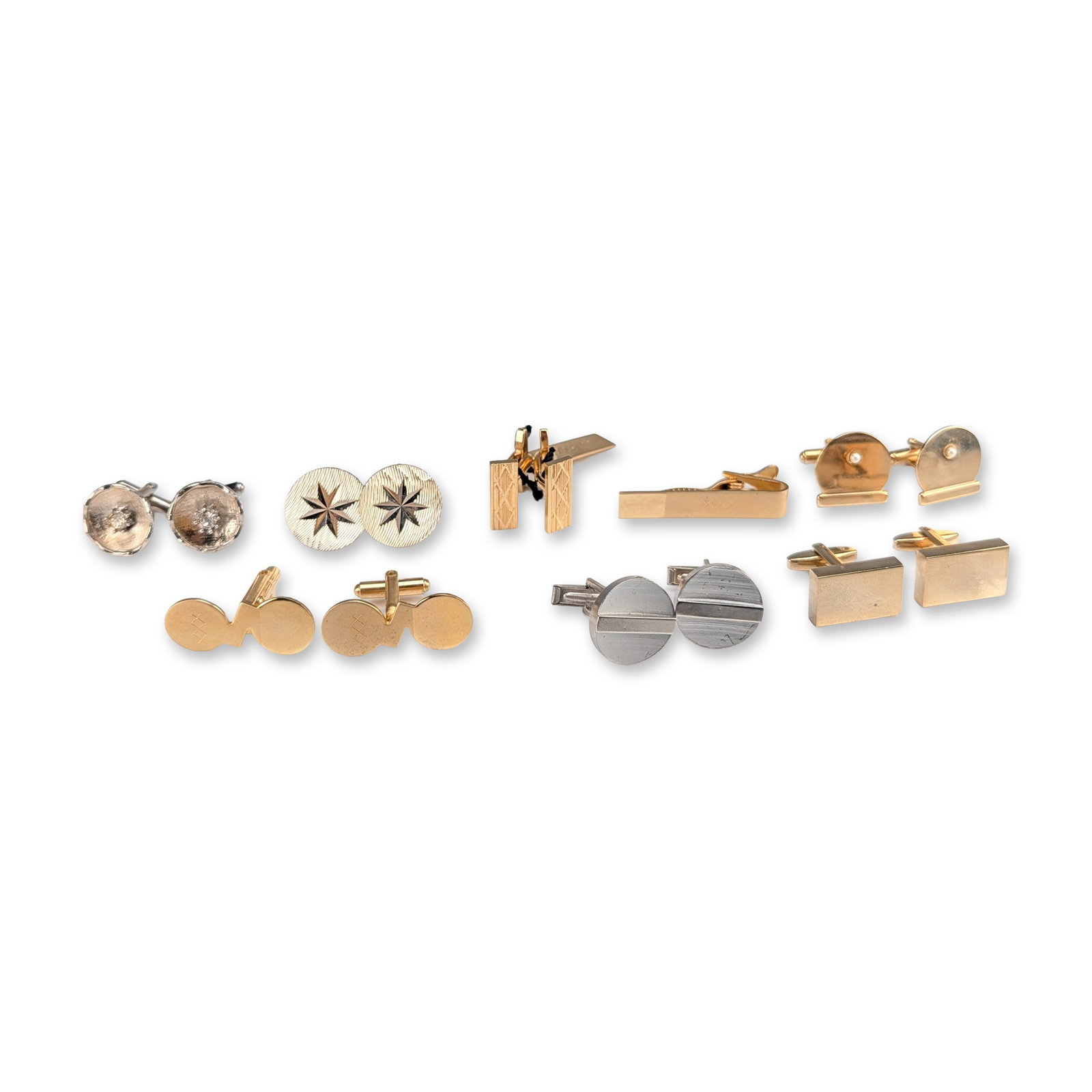 7 Pairs of Assorted Vintage Cufflinks and a Tie Clip: Assortment of vintage men's accessories including seven pairs of cufflinks and a tie clip in yellow and white metal tones. One pair of rectangular yellow-tone cufflinks features posts with impressed m