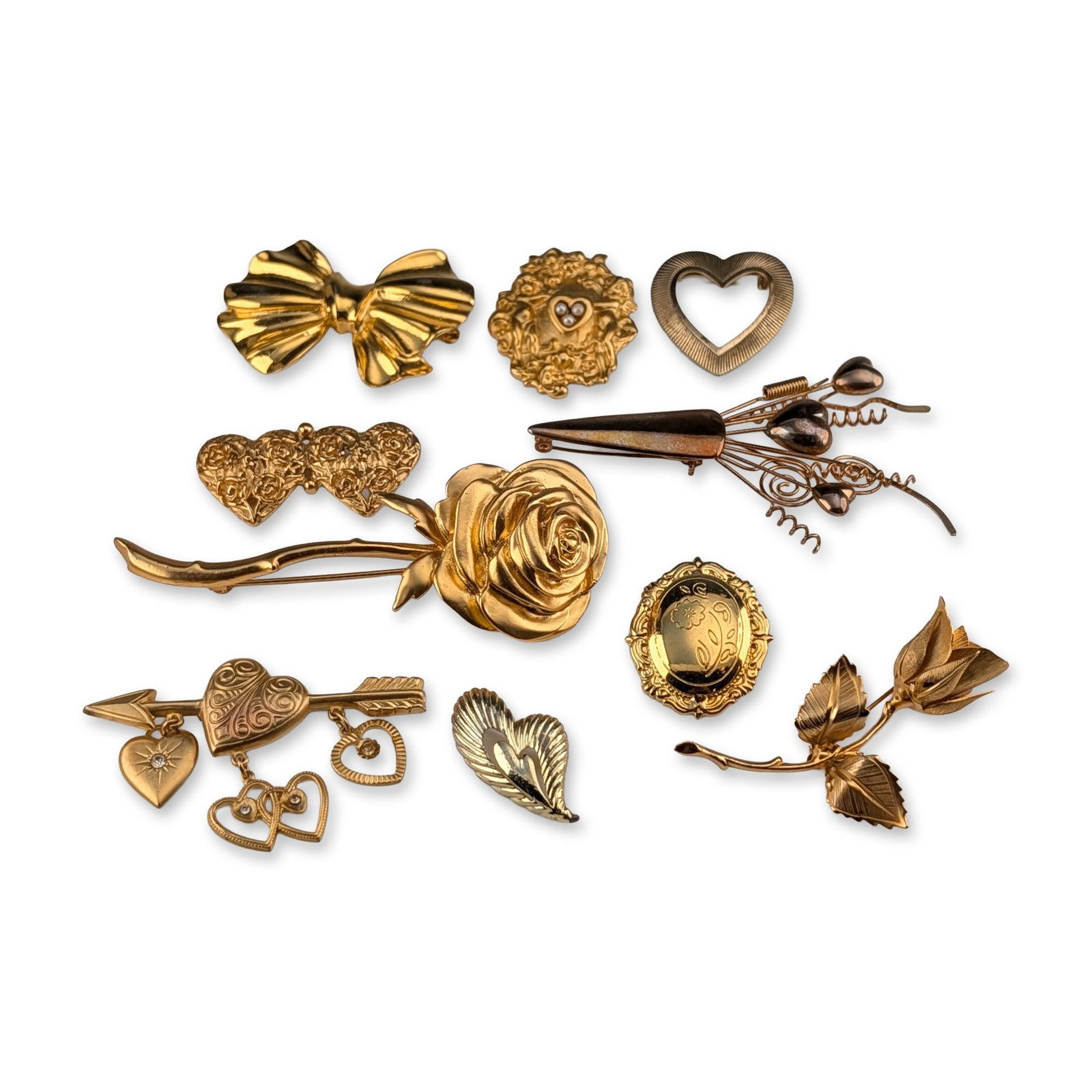 10pc Collection of Vintage Romantic and Floral Gold-Tone Brooches: A group of ten vintage fashion brooches and pins featuring romantic and floral motifs, primarily constructed from gold-tone base metal with various polished, brushed, and textured finishes. The assort