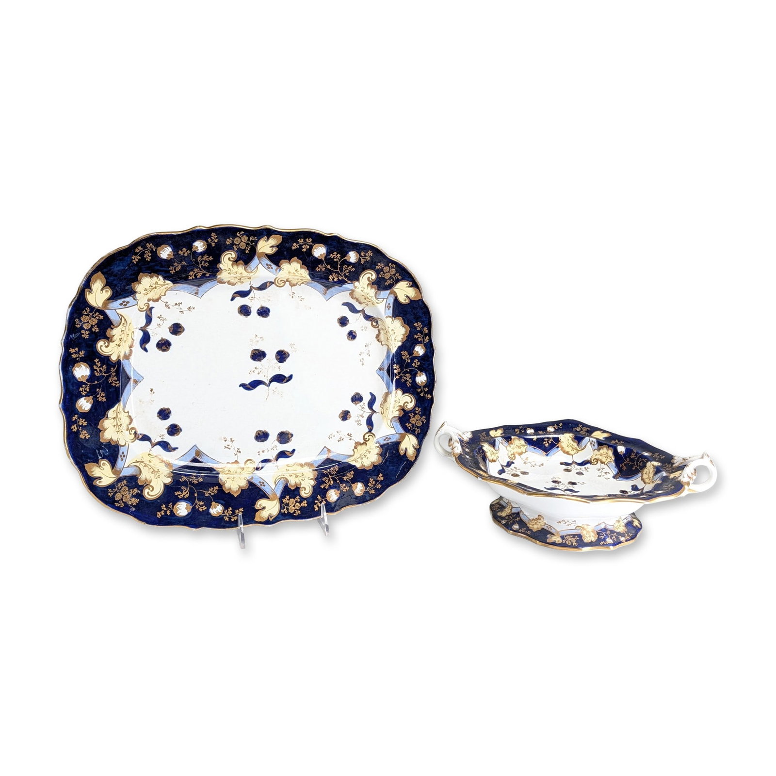 2pc Porcelain Serving Platter & Footed Bowl: Two porcelain serving pieces in a polychrome floral pattern. The set includes a large serving platter with a scalloped, gadrooned rim and a footed, double-handled bowl. The second piece features an ov