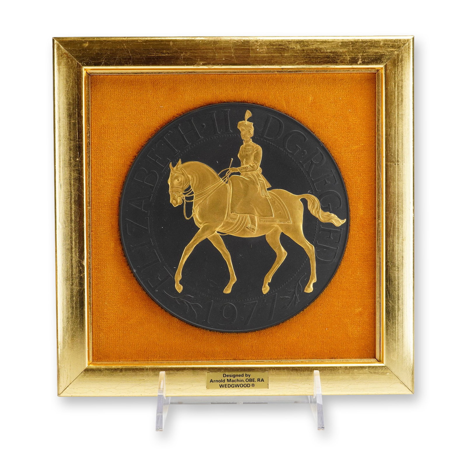 Wedgwood Arnold Machin Silver Jubilee Basalt Plaque: Wedgwood, 1977. A circular black basalt stoneware commemorative plaque featuring a parcel-gilt bas-relief of Queen Elizabeth II on horseback, riding side-saddle in her Trooping the Color uniform. Desi