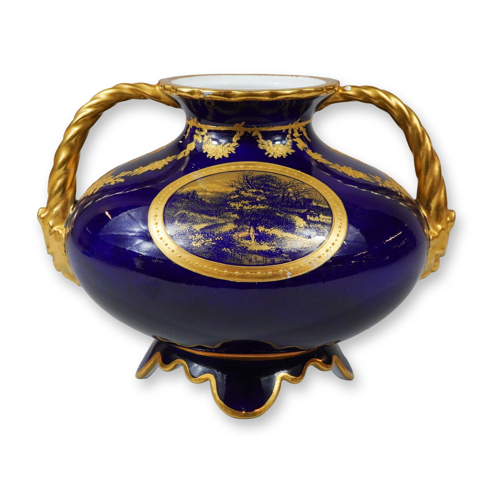 Wedgwood Cobalt Blue and Gilded Porcelain Two-Handled Cabinet Vase: This porcelain cabinet vase from Wedgwood features a deep cobalt blue ground with ornate gilded decoration. The vessel has a squat, globular form supported by a scalloped, four-lobed pedestal base. It