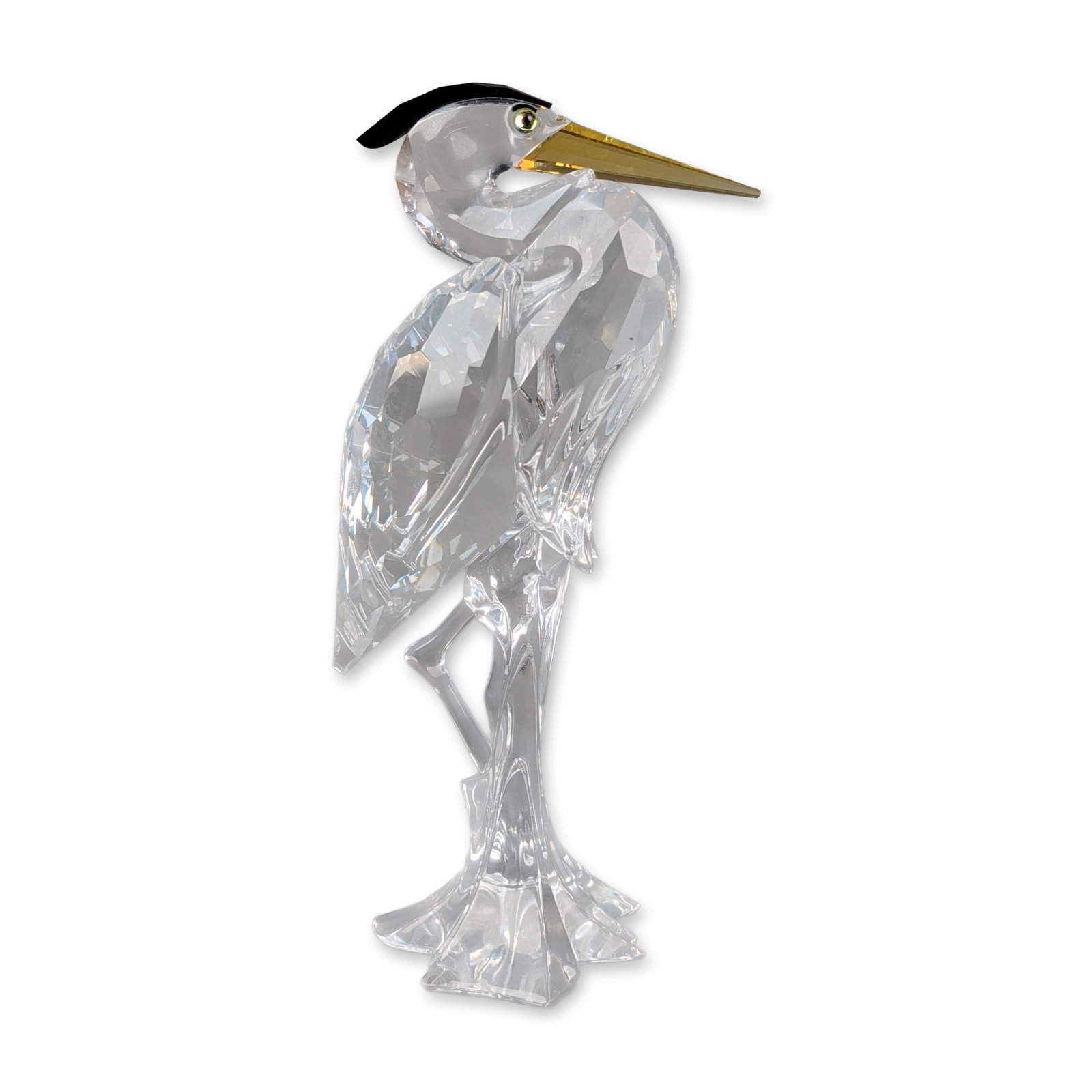 Swarovski Crystal Bird Figurine, Silver Heron: Swarovski Silver Crystal heron figurine. Crafted in clear faceted crystal, featuring an amber-colored crystal beak and a black crystal crest. The bird is shown in a standing pose with an integrated ri