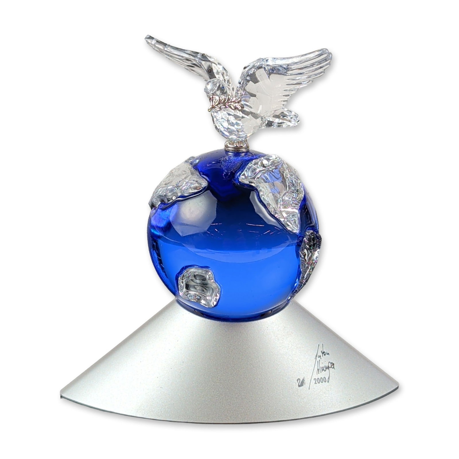 Swarovski Crystal Planet Limited Edition Figurine: Swarovski Crystal Planet figurine designed by Anton Hirzinger for the year 2000 millennium anniversary. The piece features a faceted clear crystal dove with a metal olive branch perched atop a cobalt 