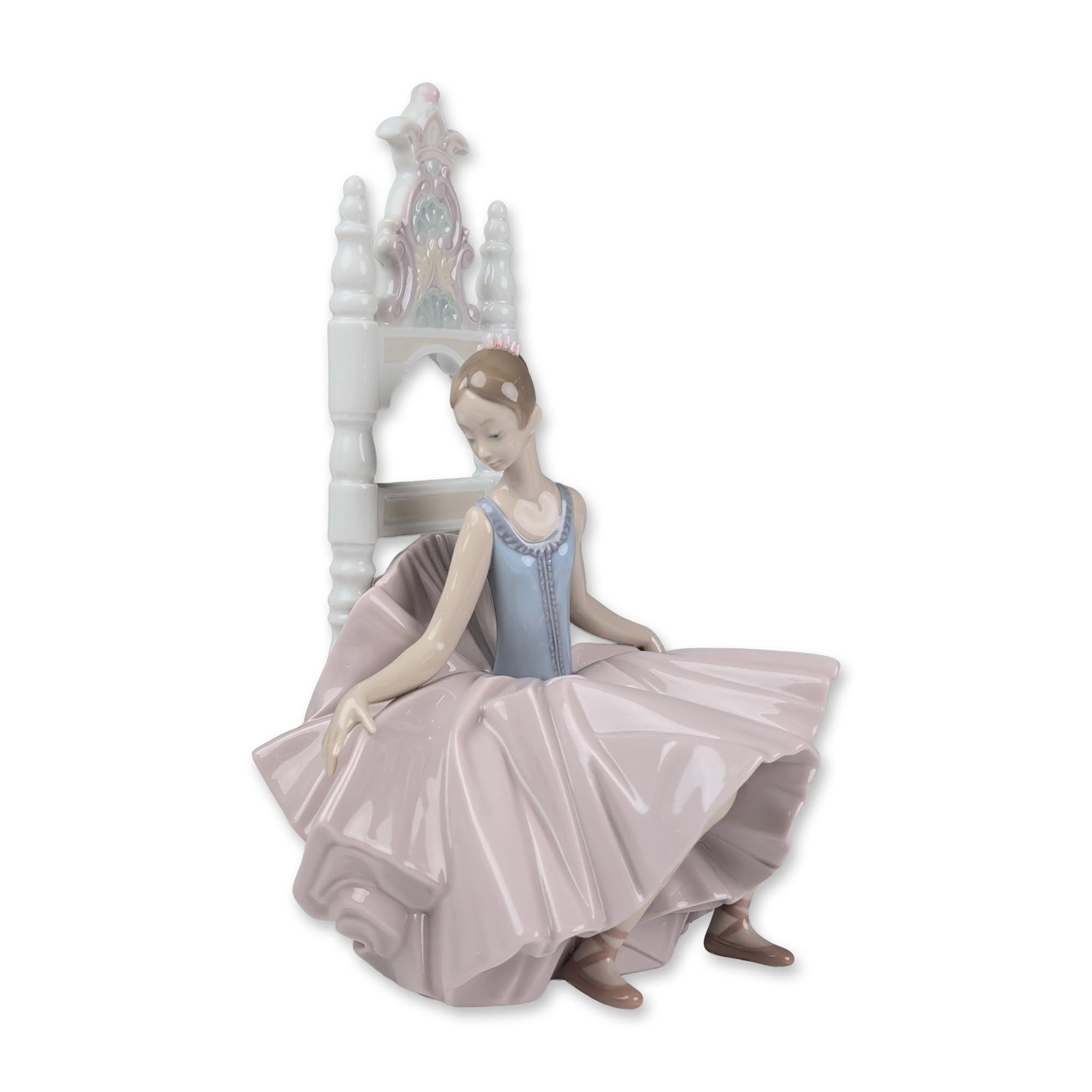 Lladro Porcelain Ballerina Figurine, After The Show 01006484: Lladro glazed porcelain figurine designed by sculptor Salvador Debon. The piece depicts a ballerina in a reflective seated pose, wearing a light blue bodice and a multi-layered ruffled skirt in a pale