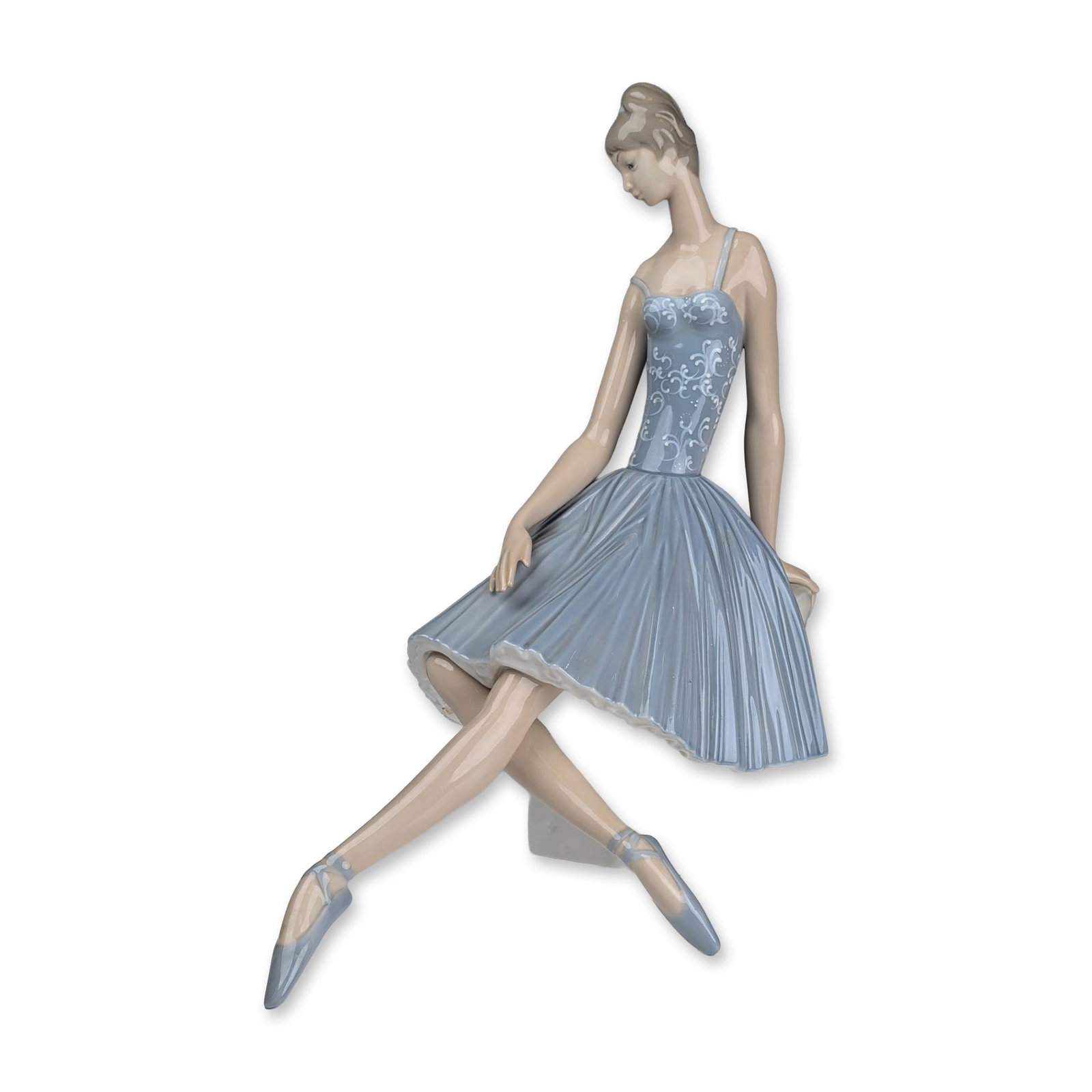 Lladro Porcelain Figurine, Waiting Backstage 01004559: Glazed porcelain figurine designed by sculptor Fulgencio Garcia. The piece depicts a seated ballerina in a pale blue bodice with white floral relief scrollwork and a pleated light blue tutu, posed upo
