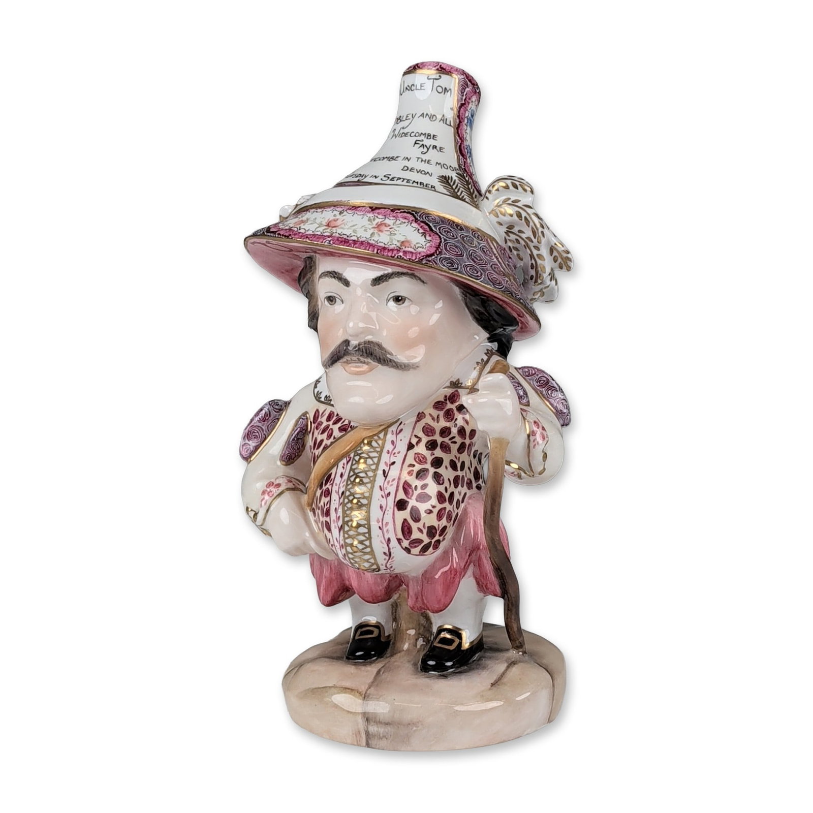 Royal Crown Derby by P. Whittaker Mansion House Dwarf Bone China Figurine, Uncle Tom: Featuring the character Uncle Tom Cobley. The figure is modeled in elaborate costume with a wide-brimmed hat, ruff collar, and patterned vest. The hat is inscribed with references to Widecombe Fair in